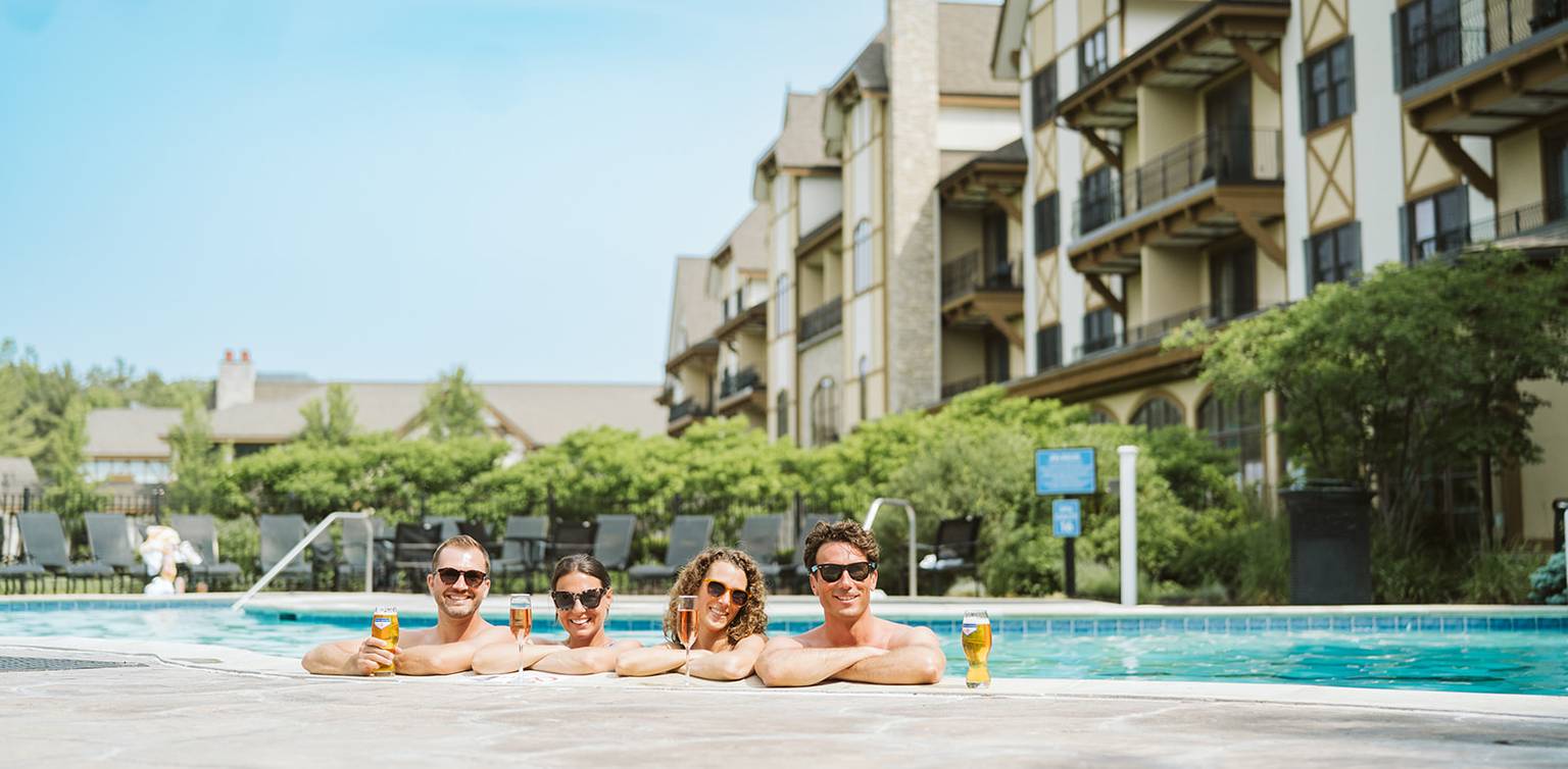 two couples in the mountain grand lodge pool in the summer