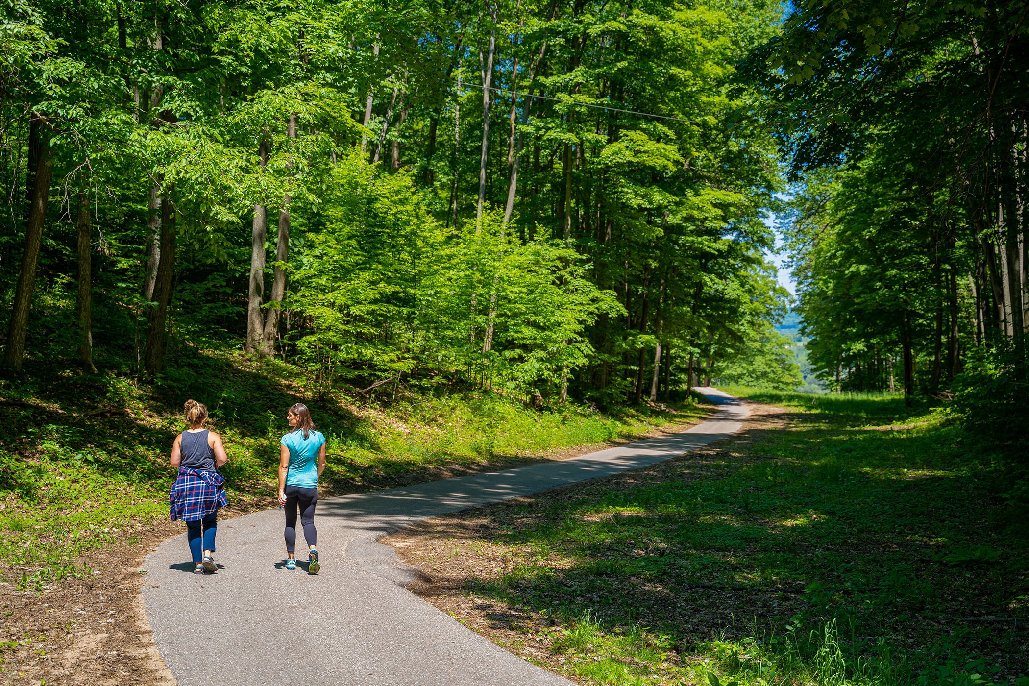 Two ladies walking on paved walking trail.
