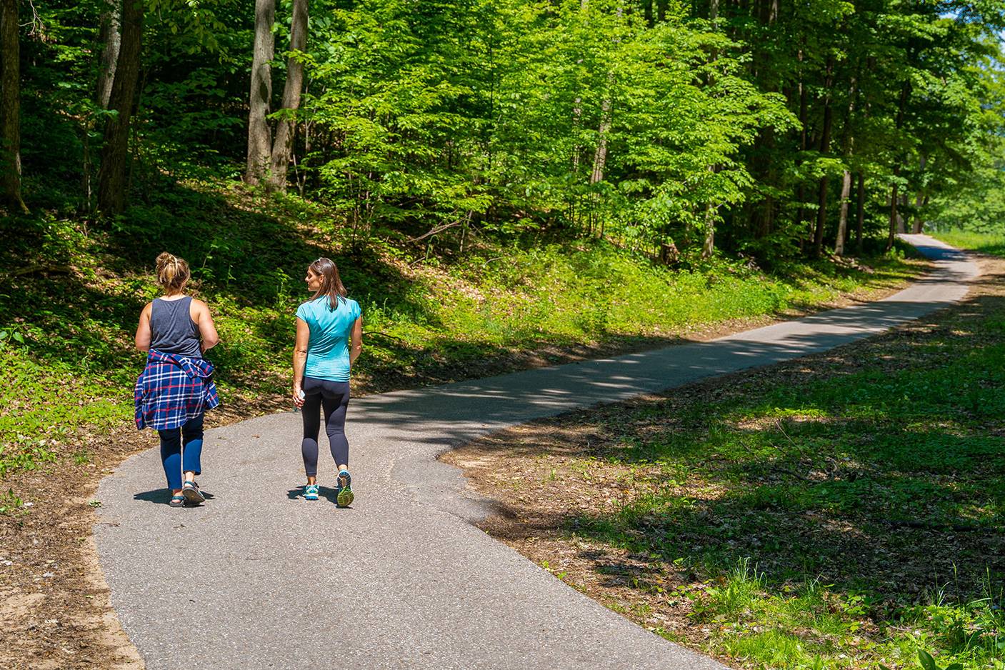 Two ladies walking on paved walking trail.