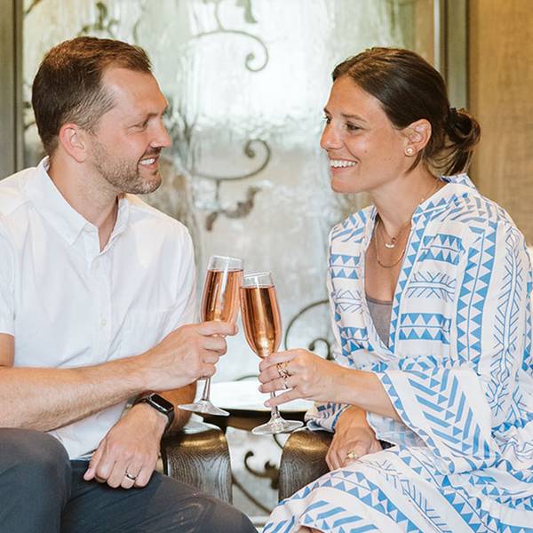 A couple doing cheers with Champagne in Chalet Edelweiss