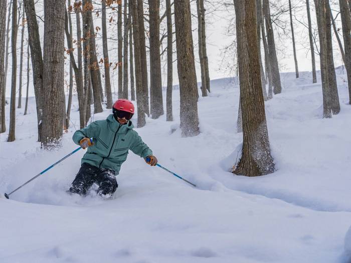 man skiing through the trees
