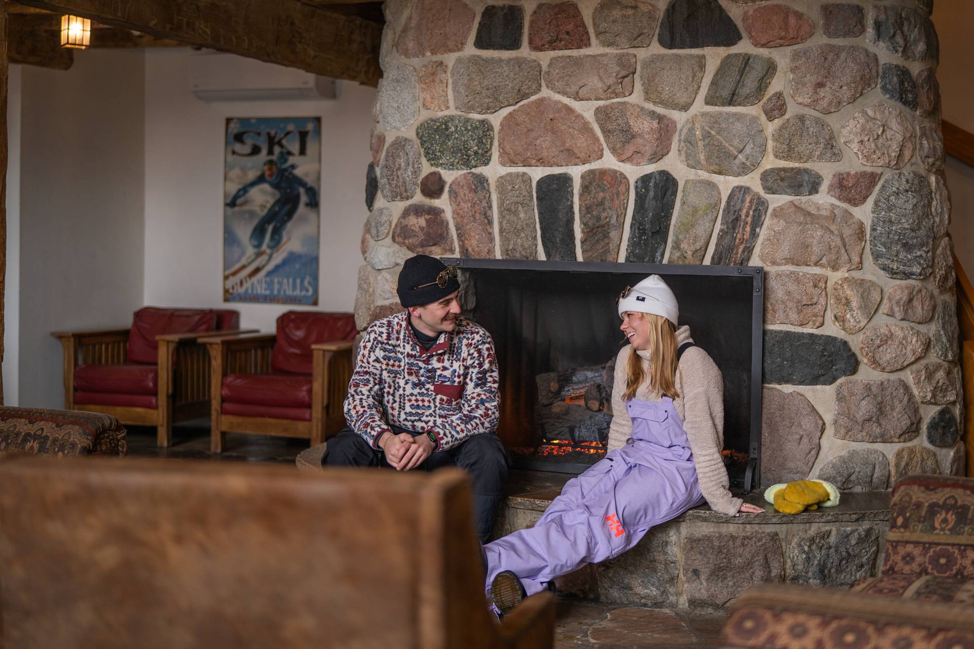 couple sitting by fireplace at resort