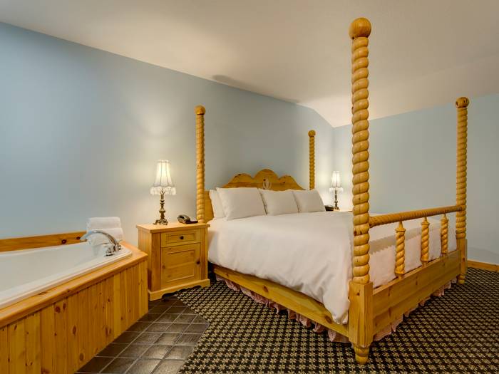 Bed and hot tub inside Arberg room.