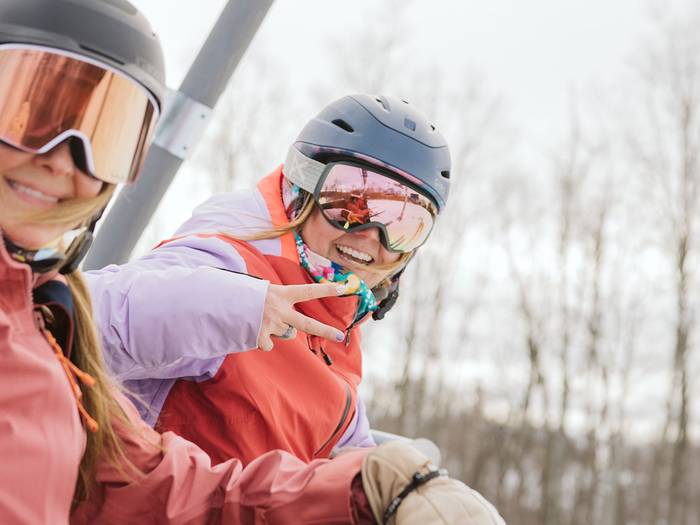 girls on lift throwing peace sign