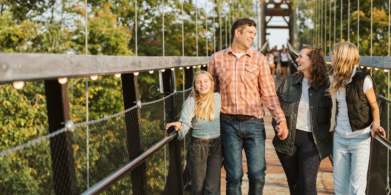 Family walking across the skybridge with dad