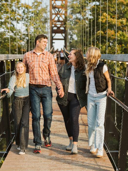 Family walking across the skybridge with dad