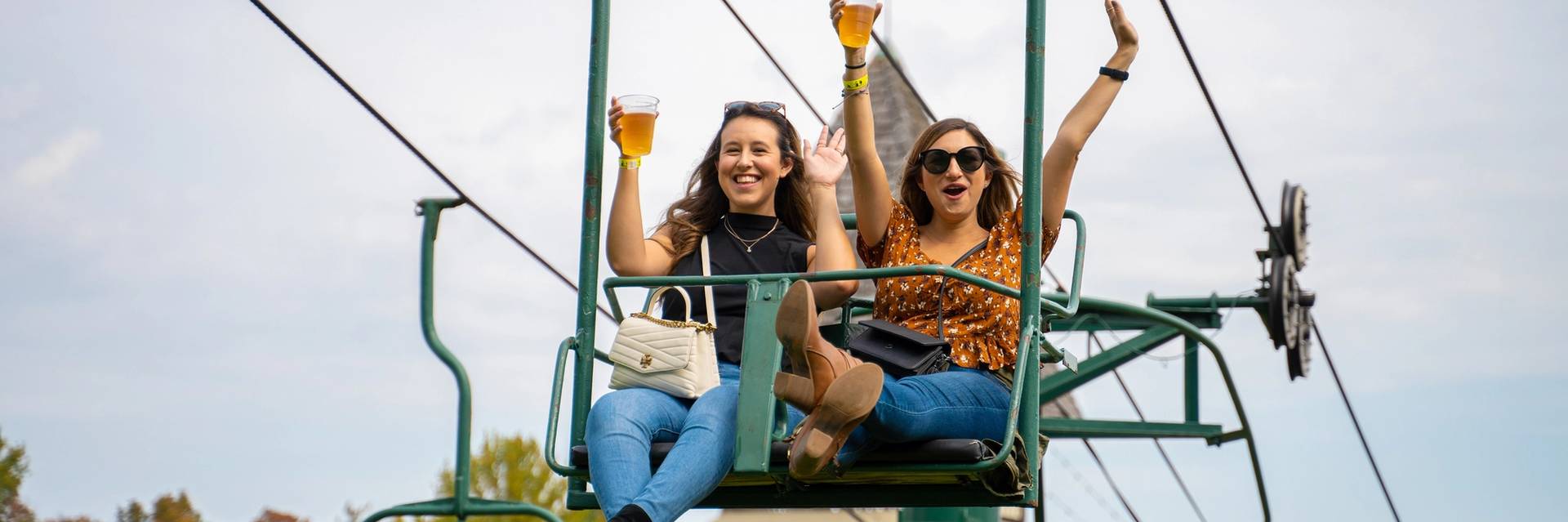 Girls riding chairlift with drinks