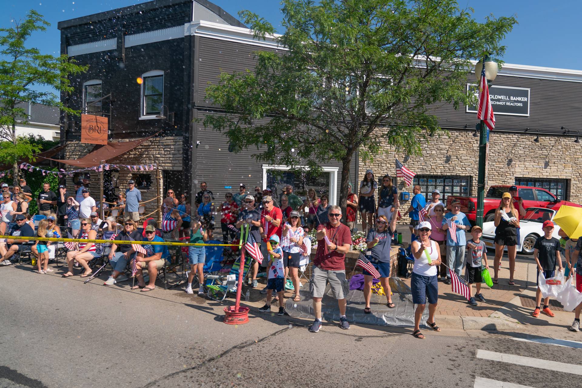 Parade watchers spray parade participants with water guns