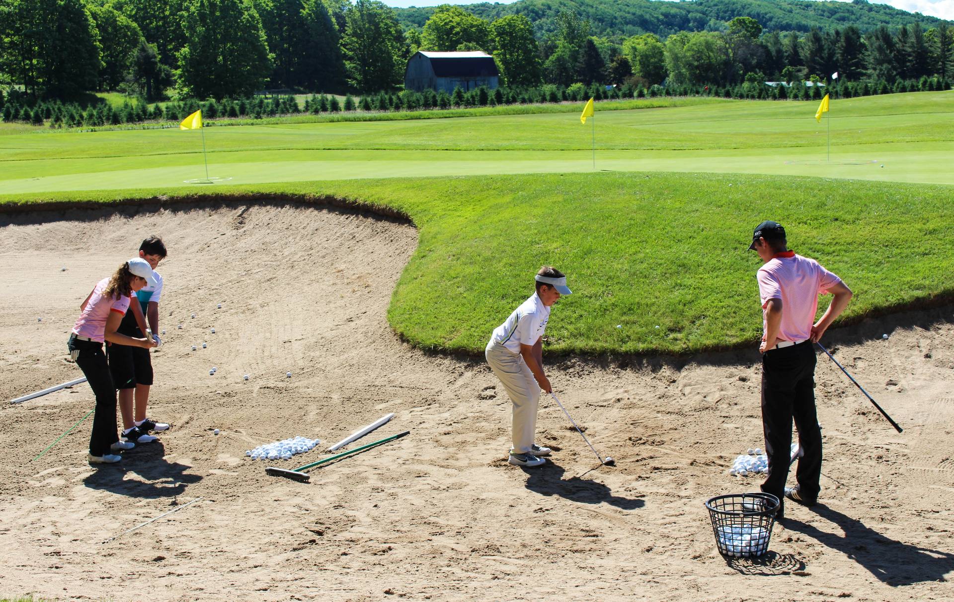 Two boys receiving golf instruction