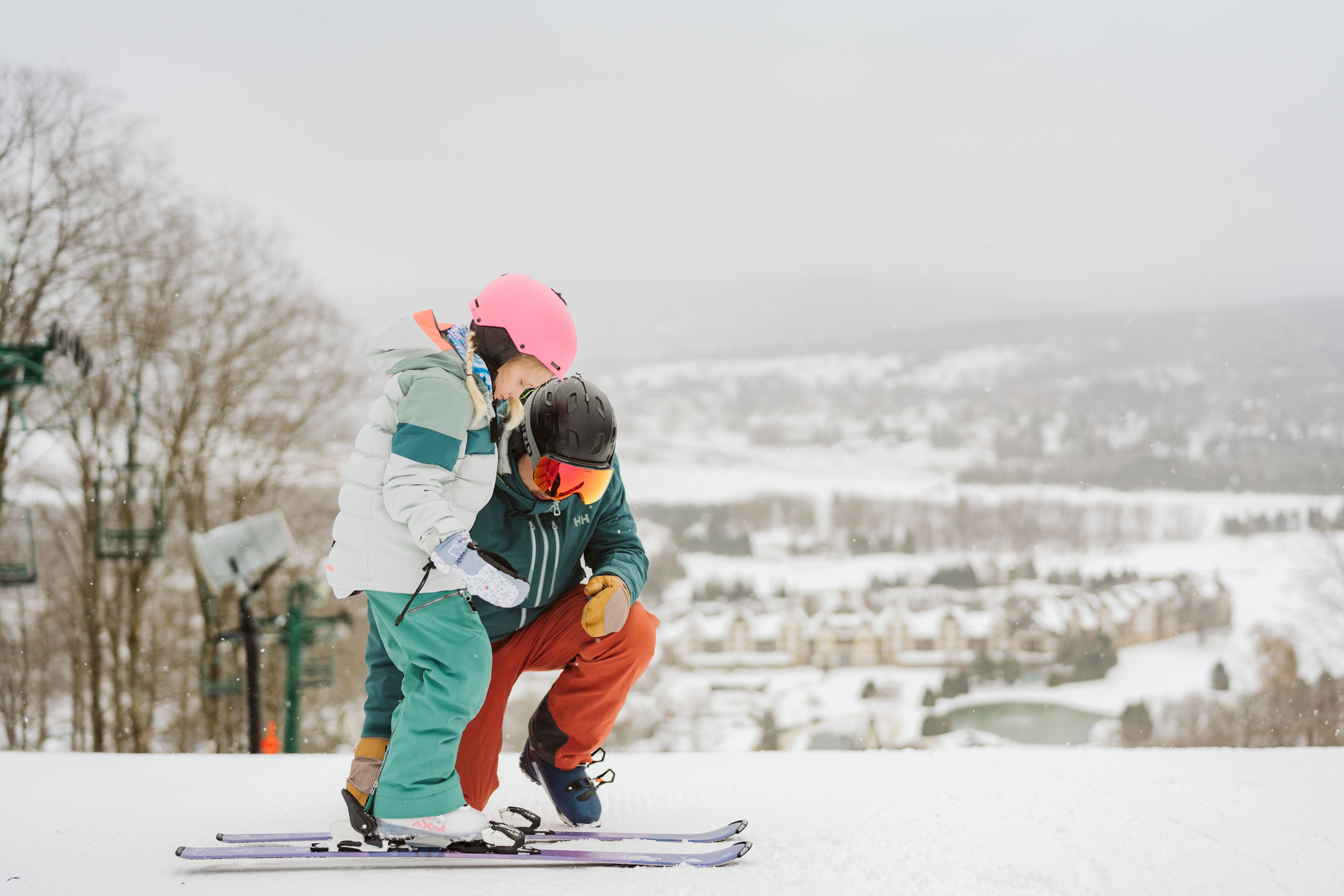 man holding child in ski boots