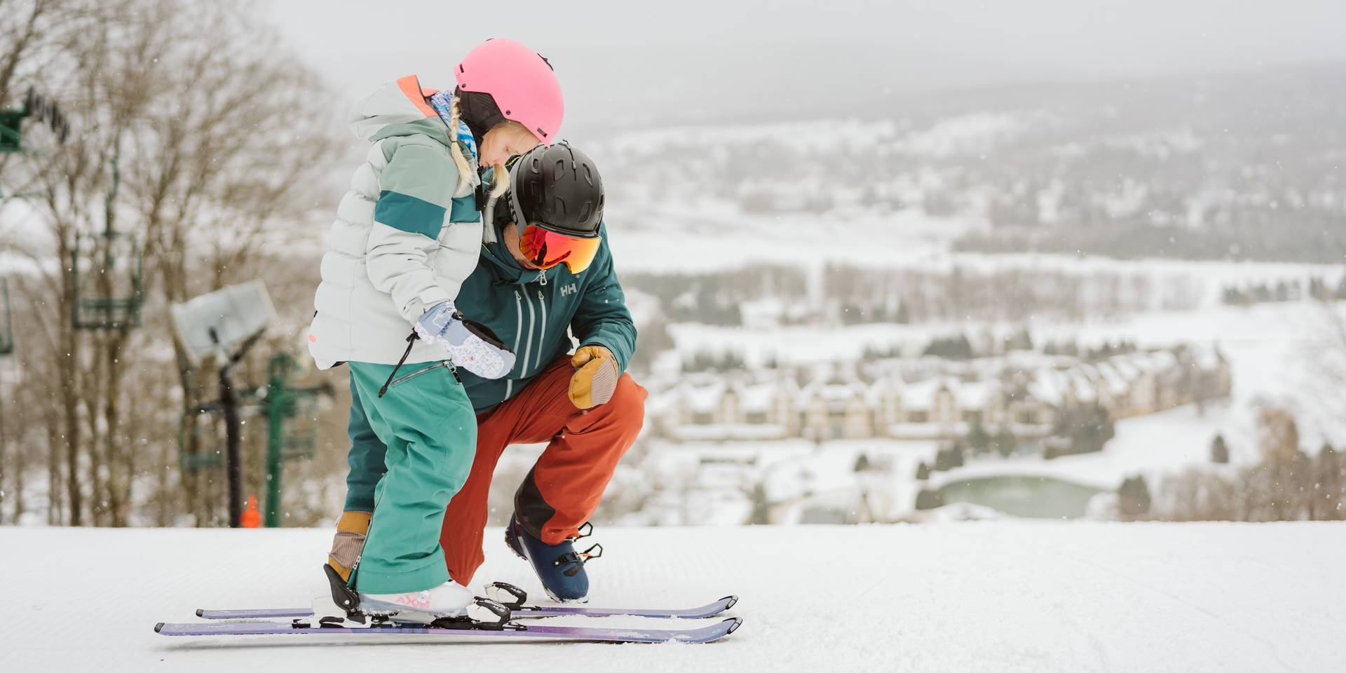 man holding child in ski boots