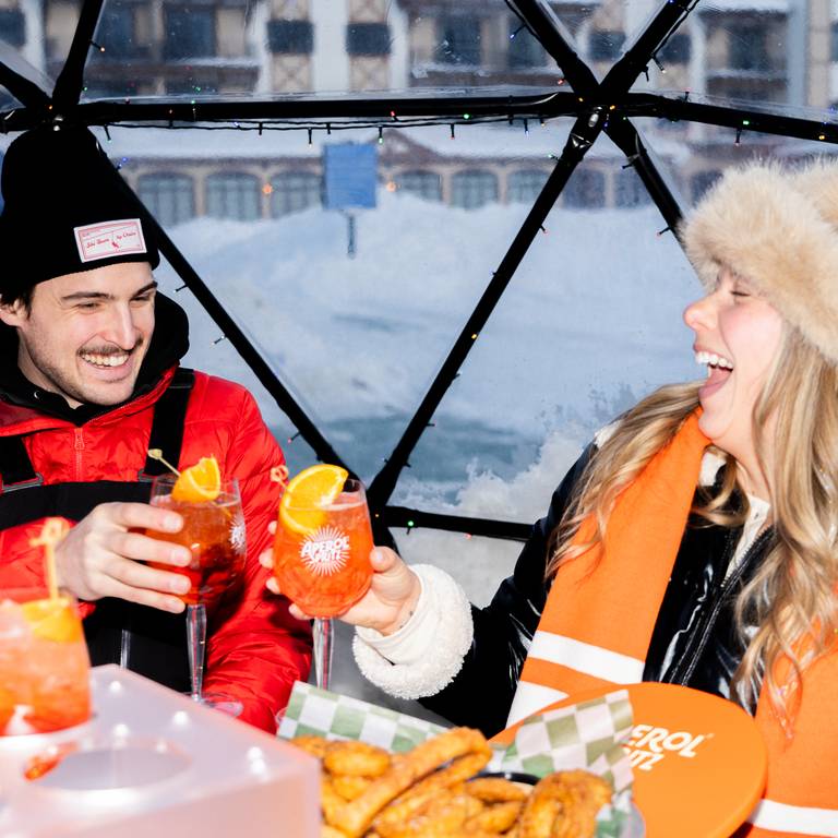 couple toasting inside igloo