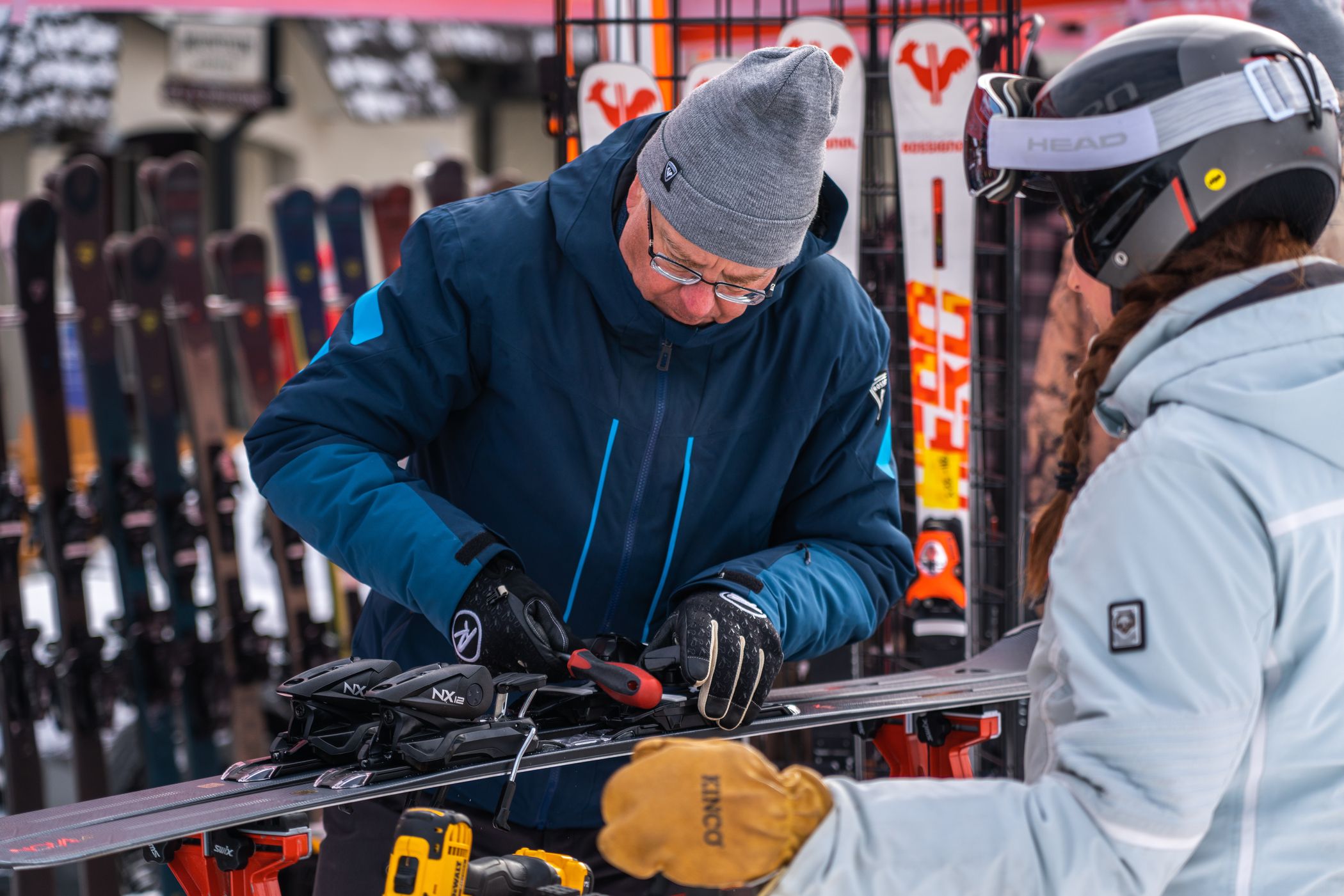 ski rep setting up skis for guest