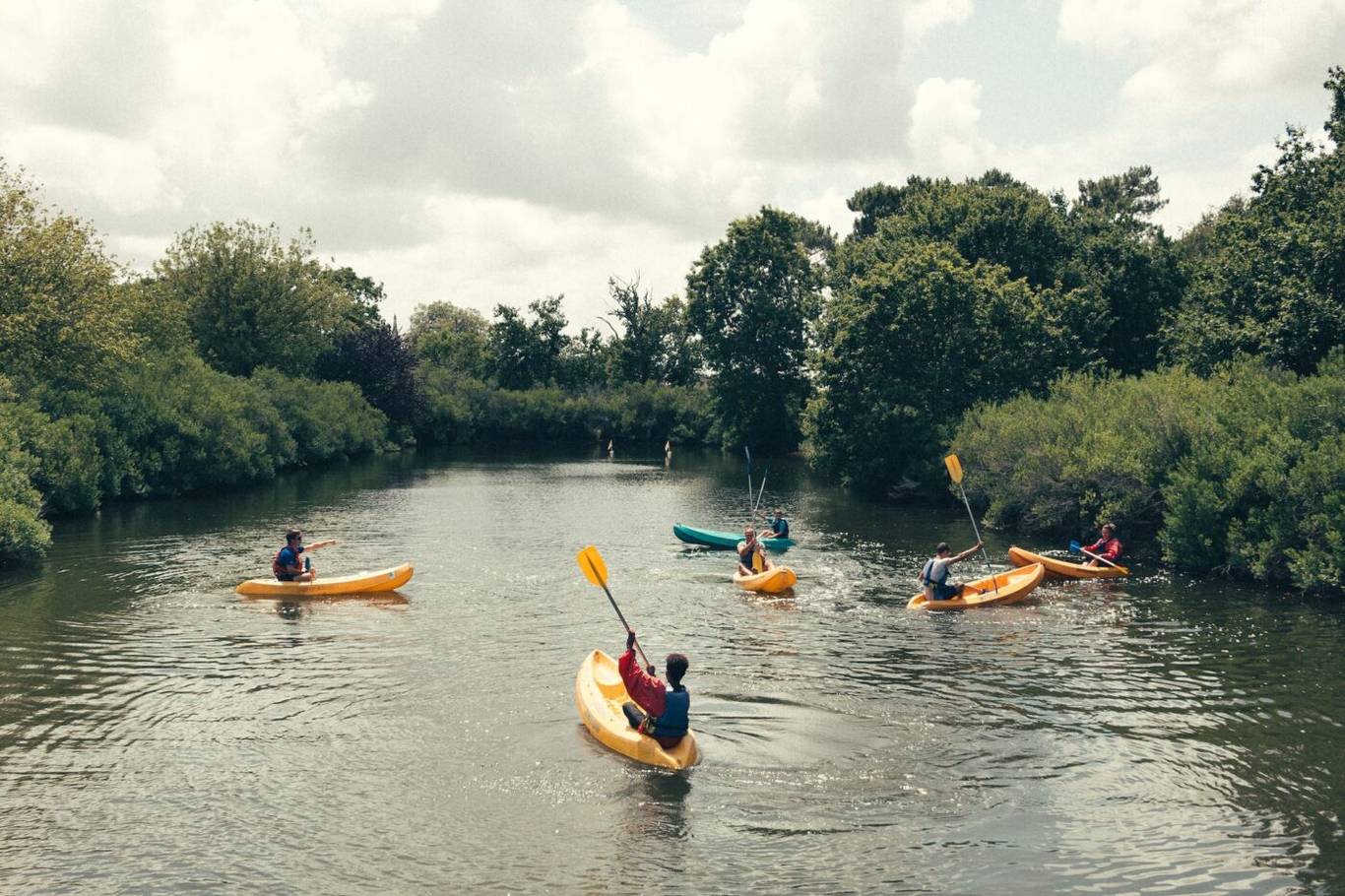 Group kayaking on a river in Northern Michigan