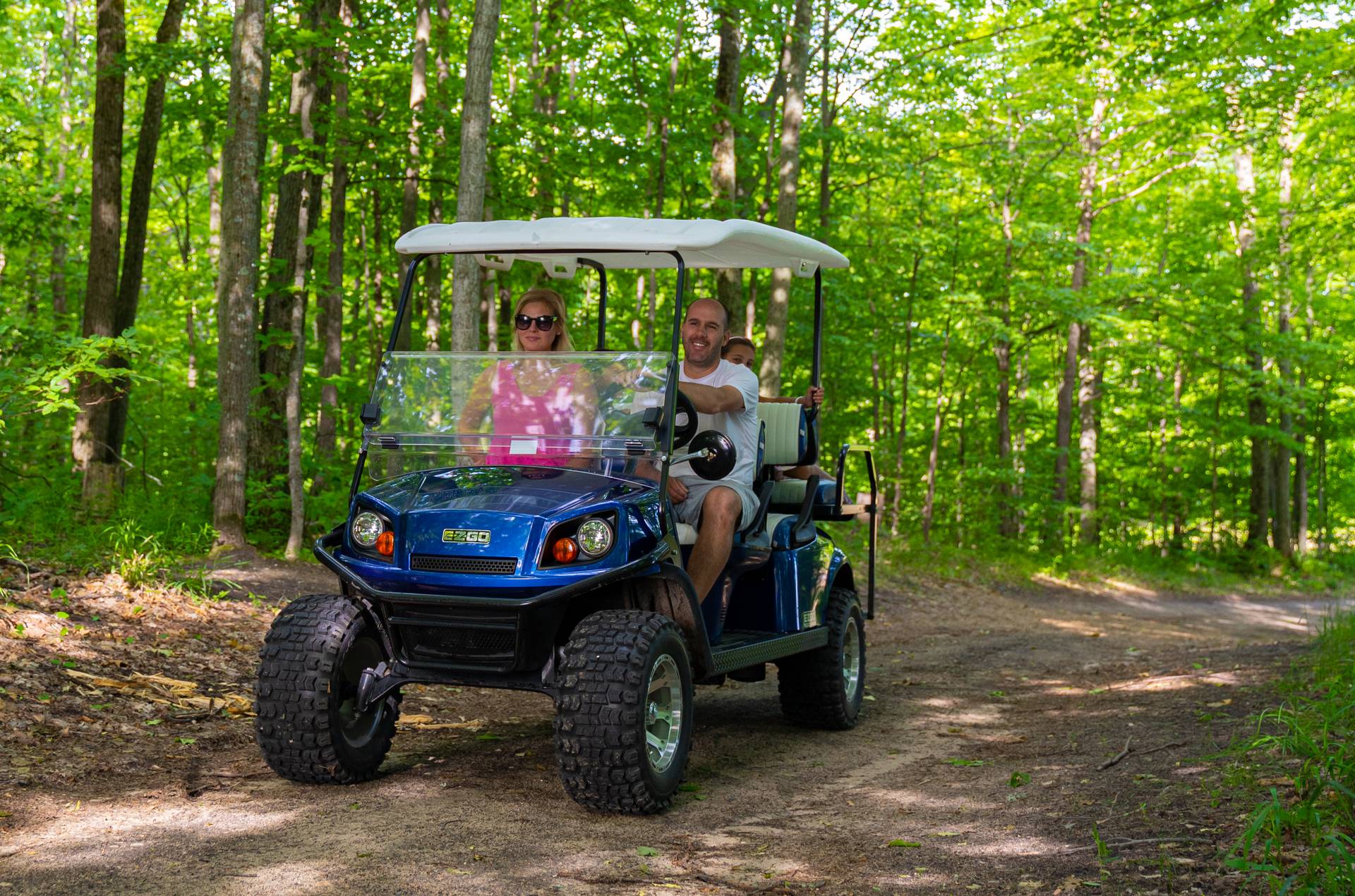 Family on scenic cart riding on a dirt trail