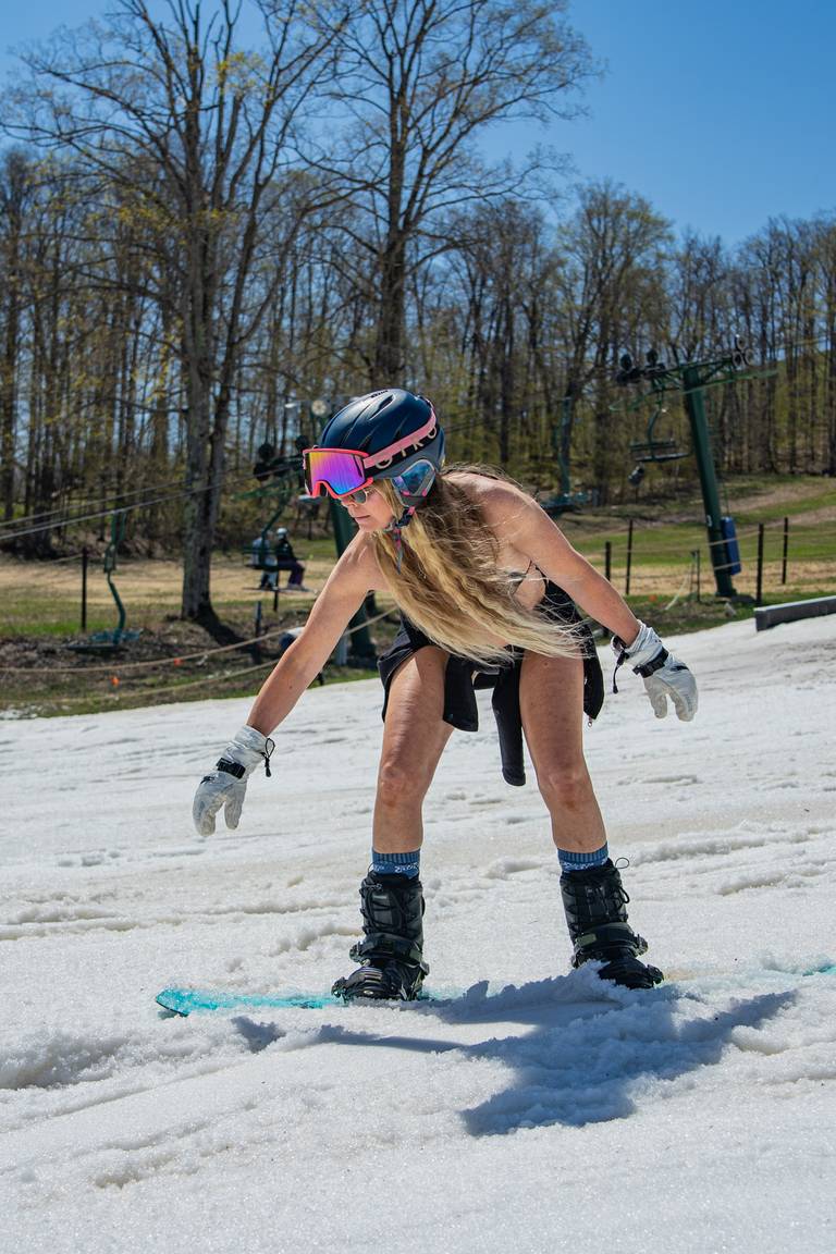 woma riding down ski slope in bikini