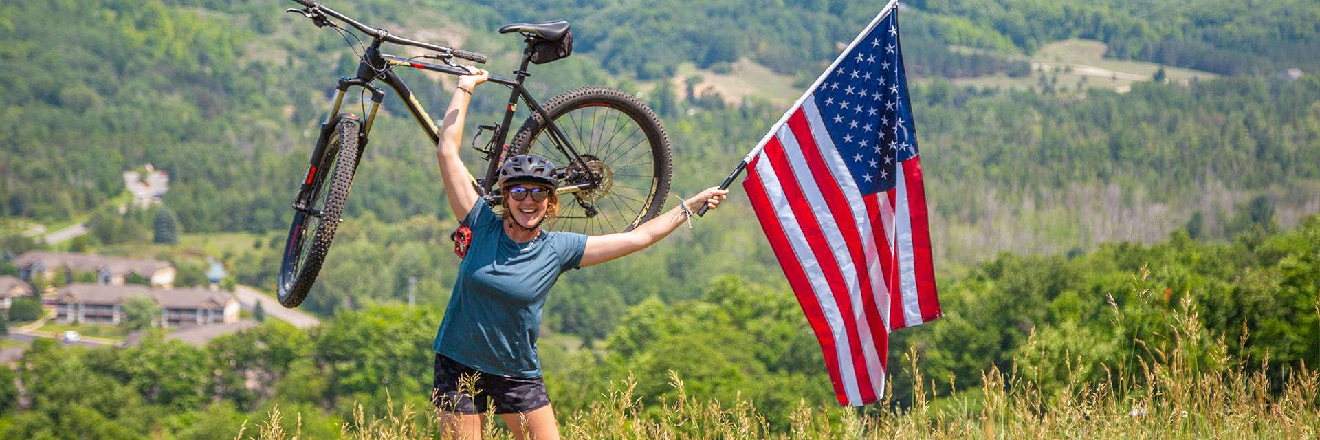 Woman holding American Flag and bike