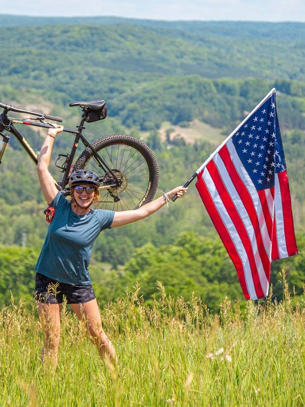 Woman holding American Flag and bike