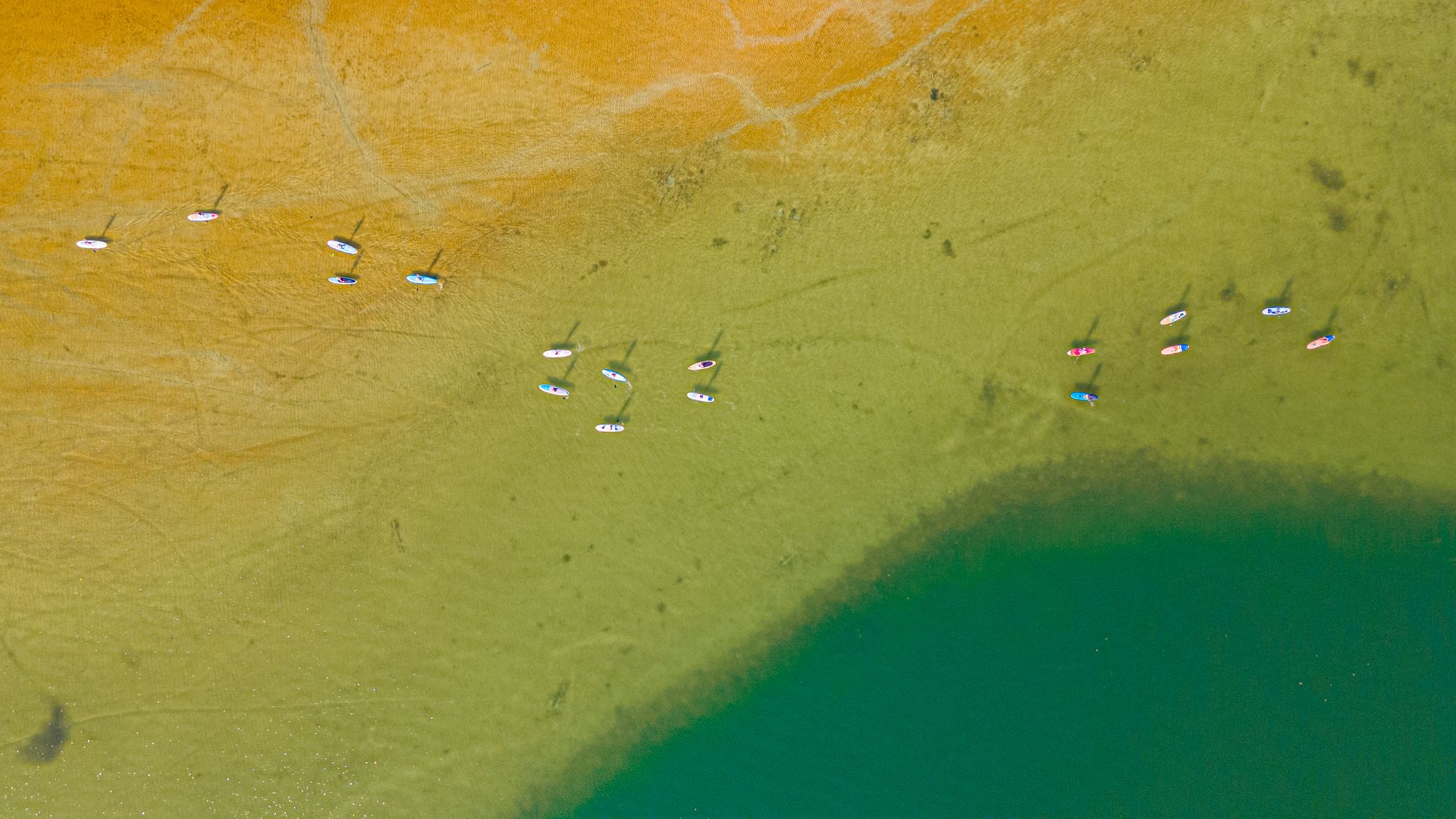 people on paddle boards on deer lake