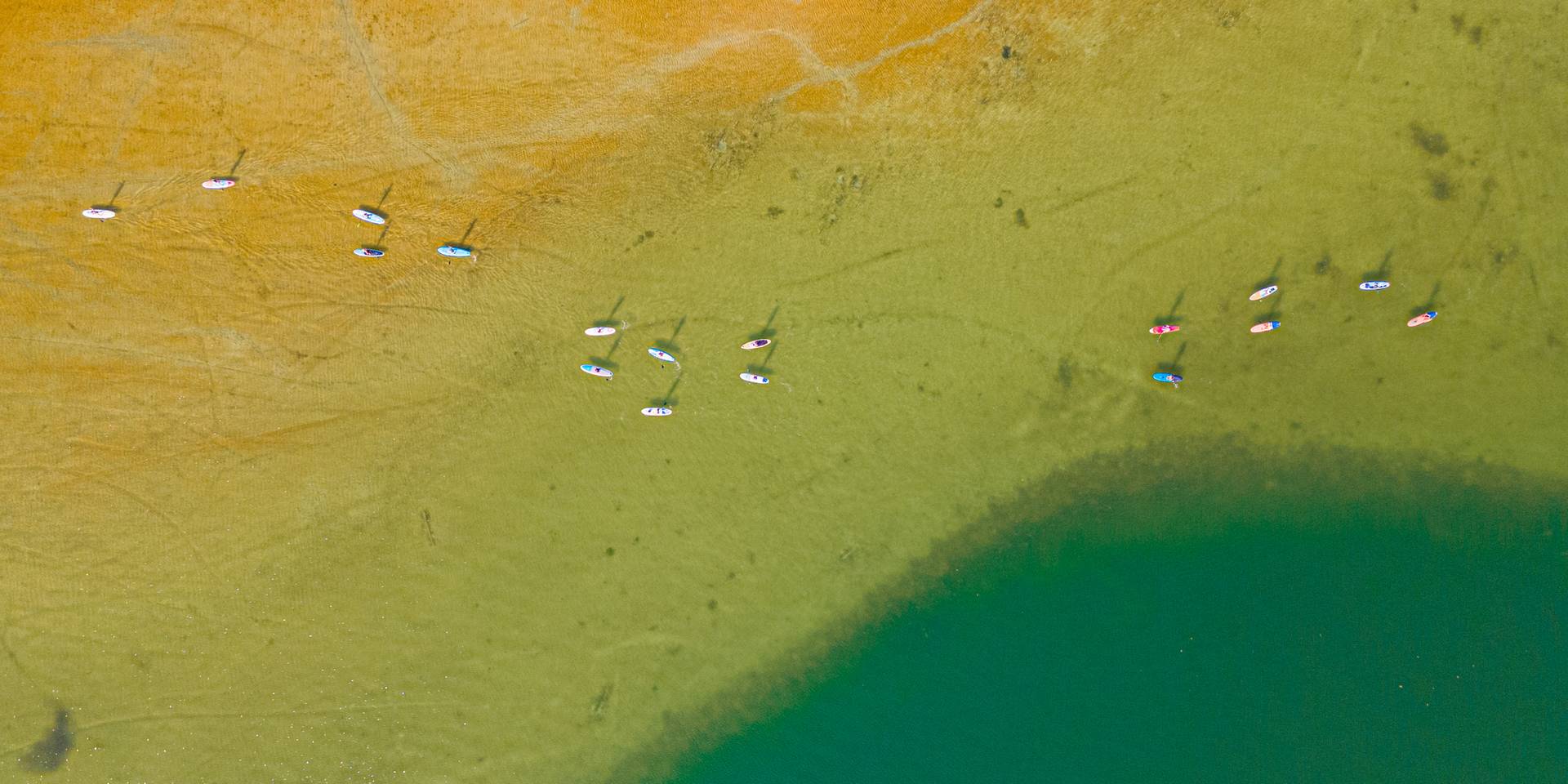people on paddle boards on deer lake