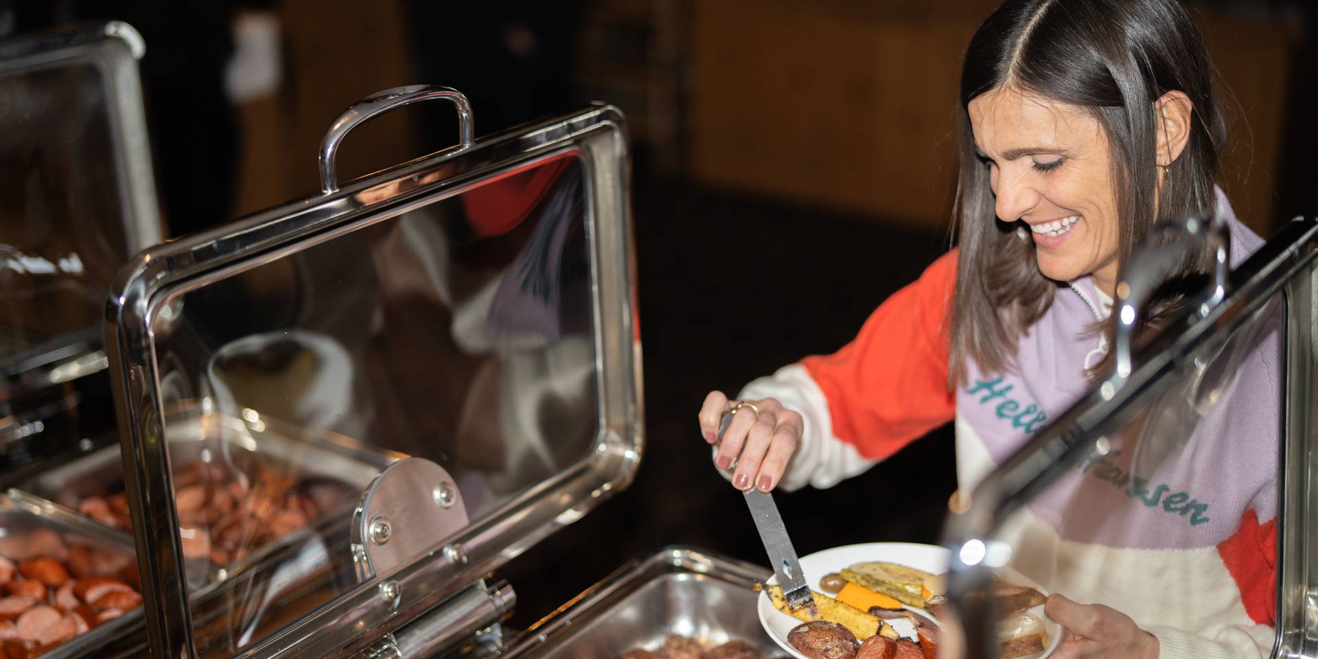 Lady pulling food off buffet