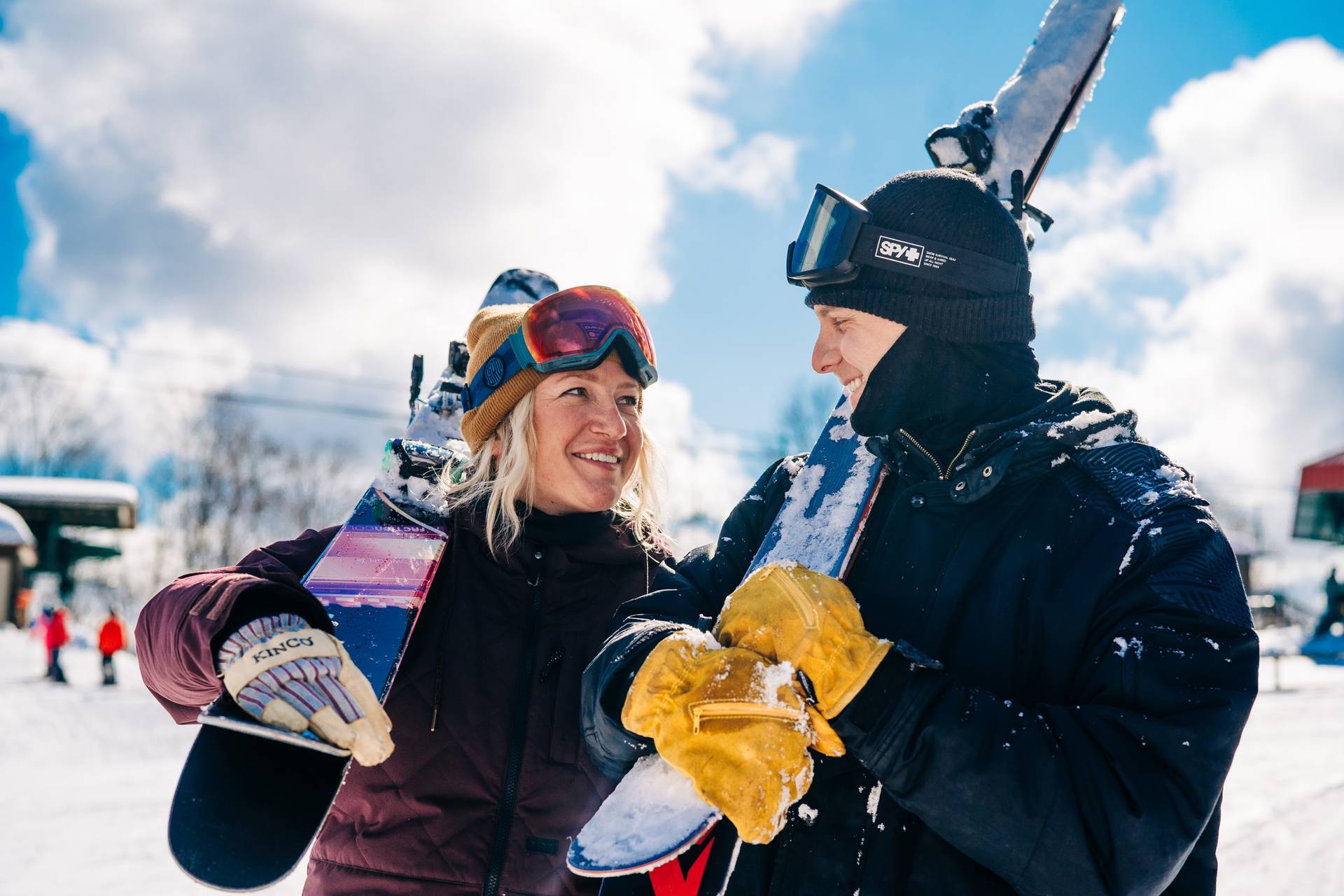 Skiing couple holding skis and smiling