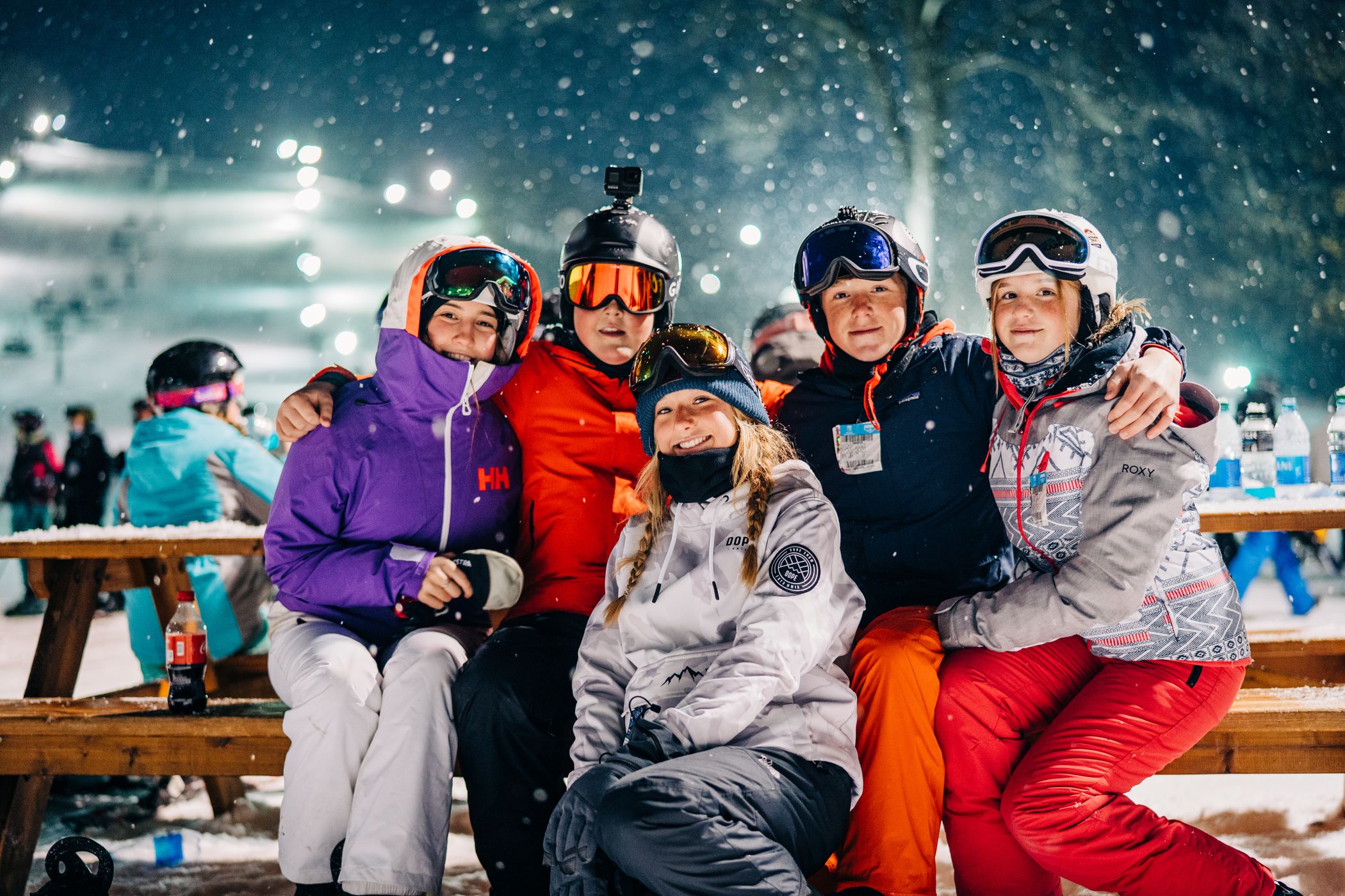 young skiers gather at table under the lights