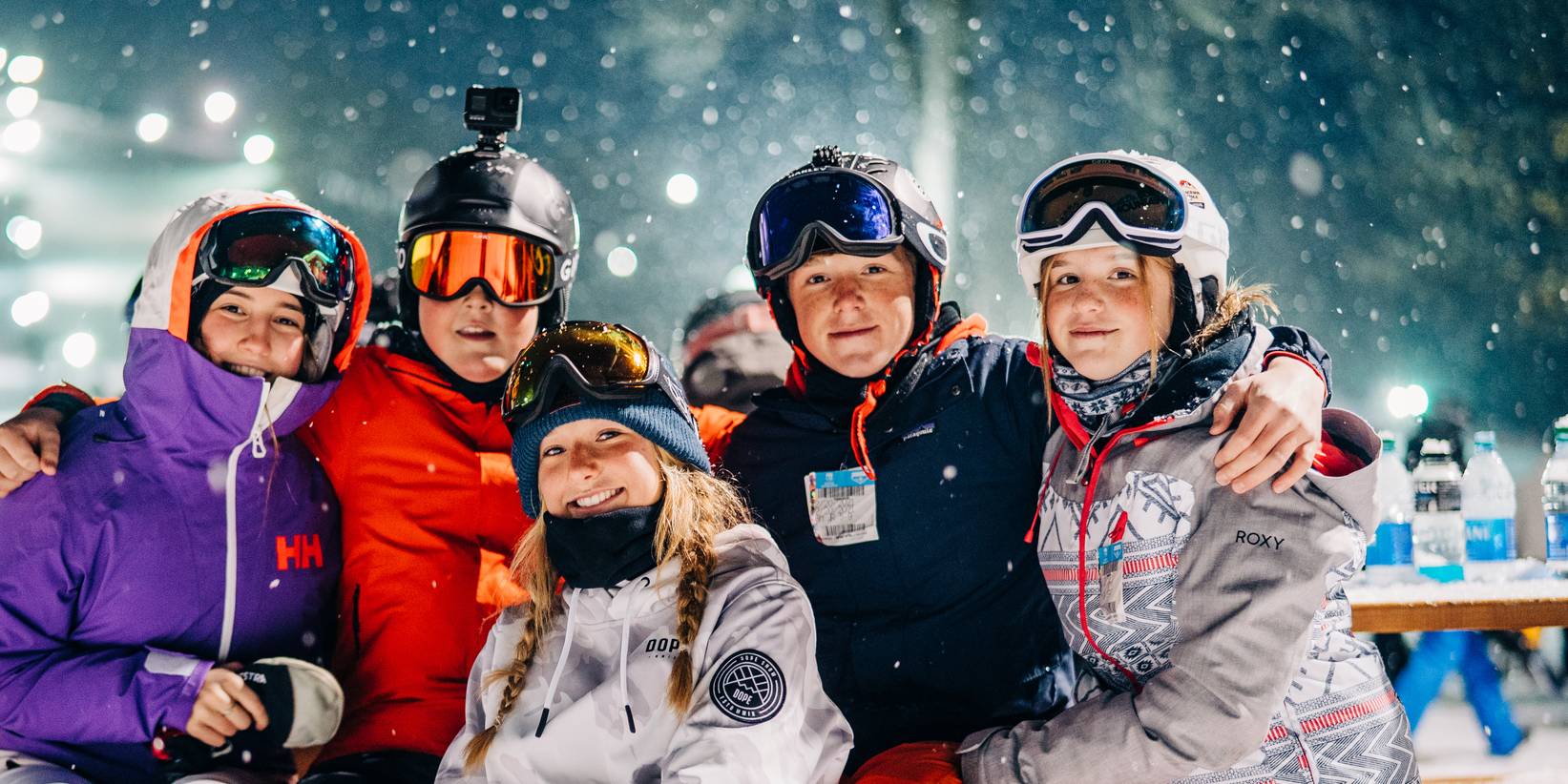 young skiers gather at table under the lights