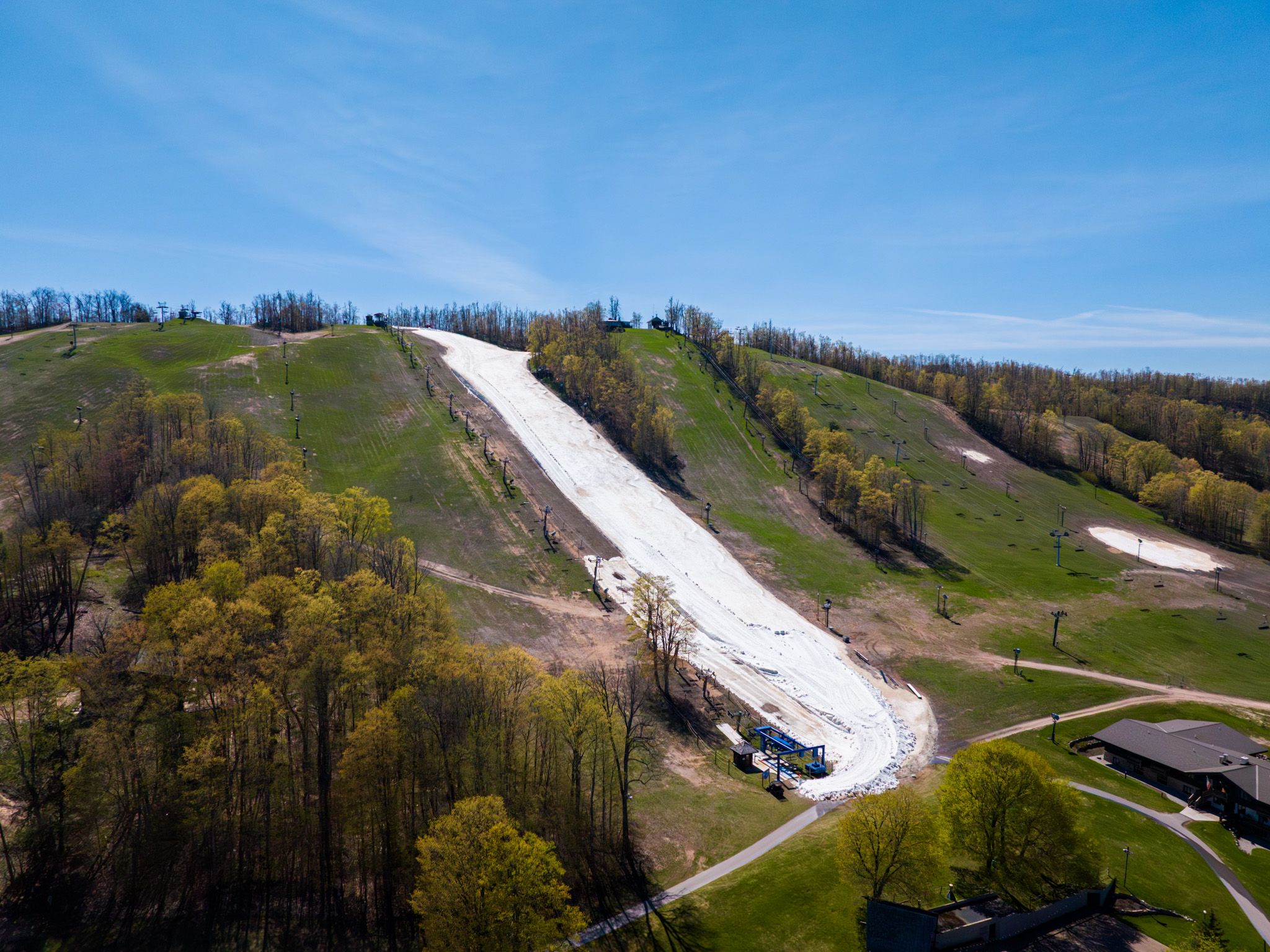 Drone shot of Victor Glacier with blue skies and green trees