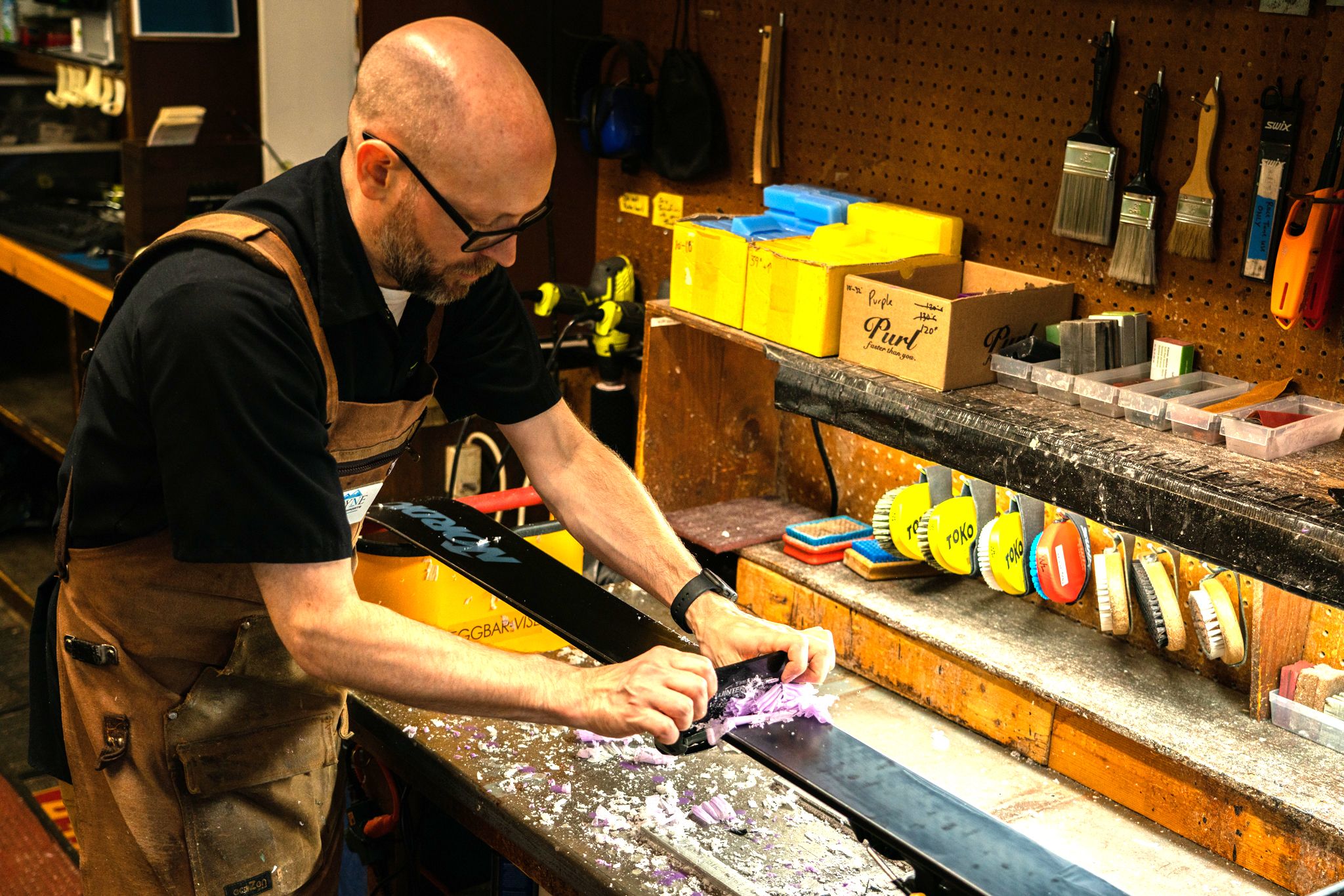 man waxing skiis in the shop