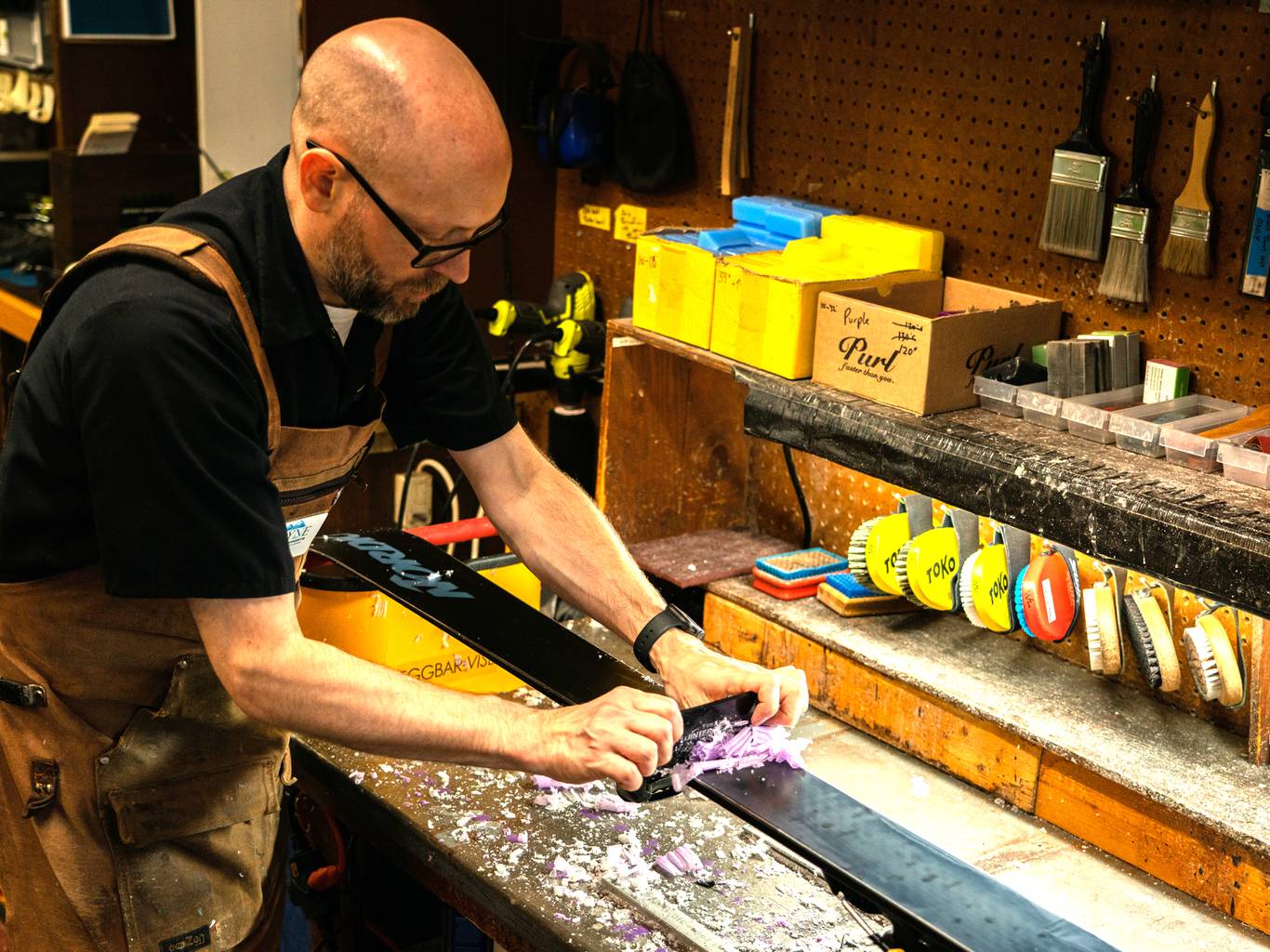 man waxing skiis in the shop