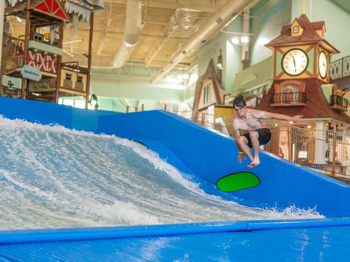 Person riding surf simulator at Avalanche Bay
