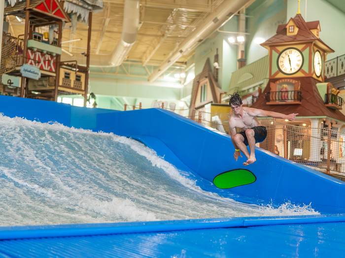 Person riding surf simulator at Avalanche Bay