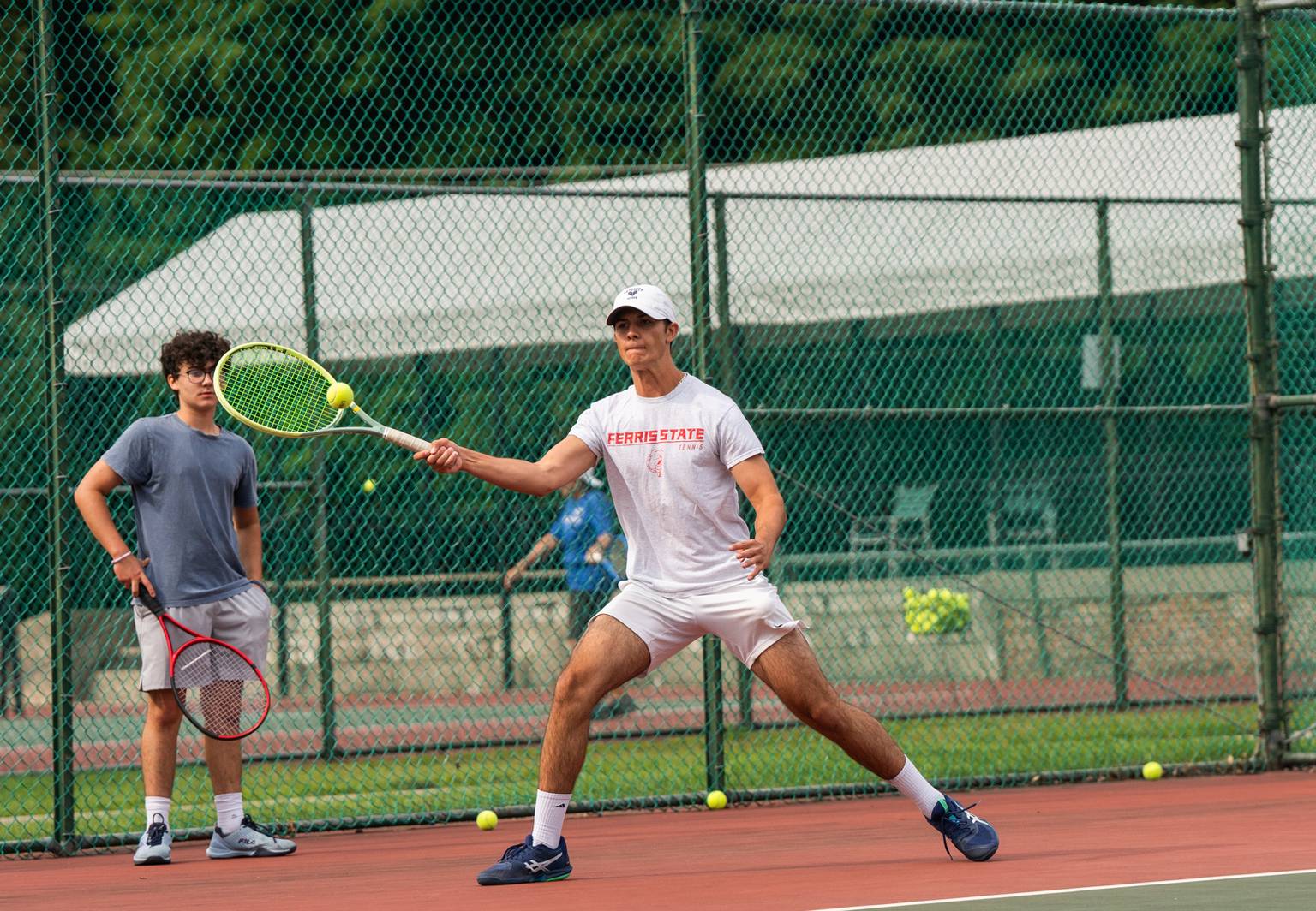 Guy hitting a tennis ball
