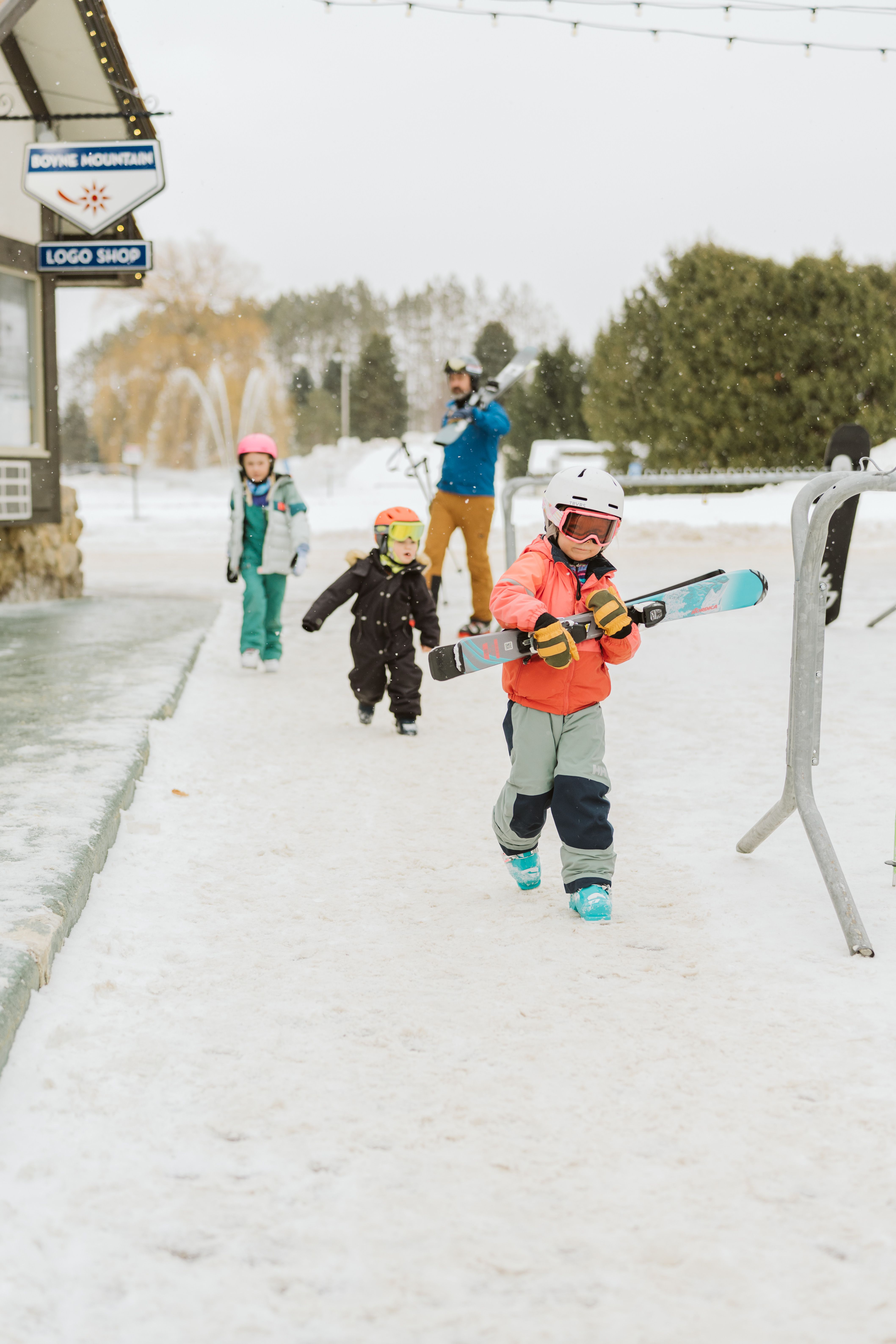 family of skiers walking through village