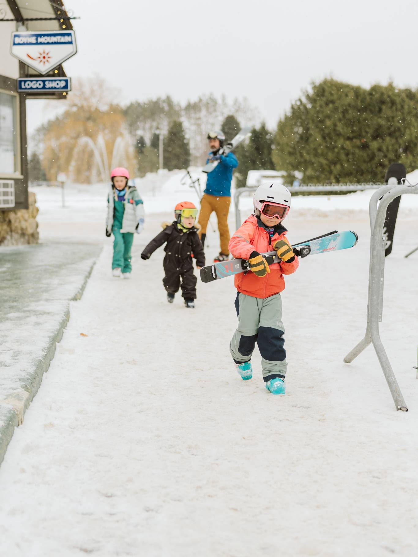 family of skiers walking through village