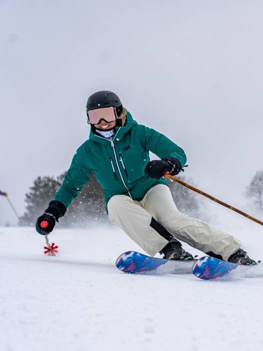 Skier smiling while ripping down slope