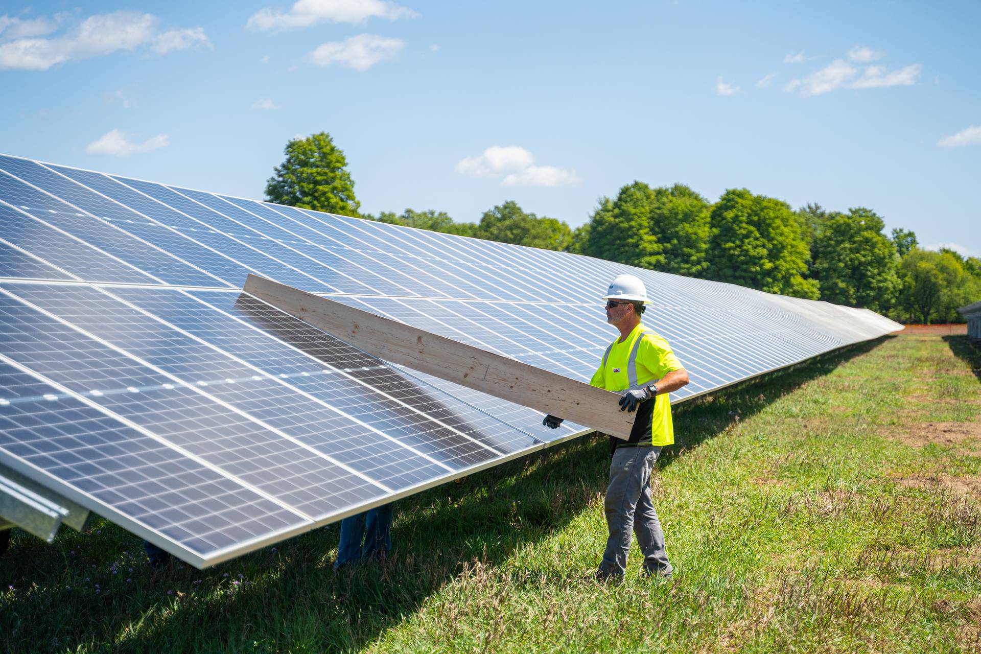 Worker installing solar panels in Boyne Mountain's solar field