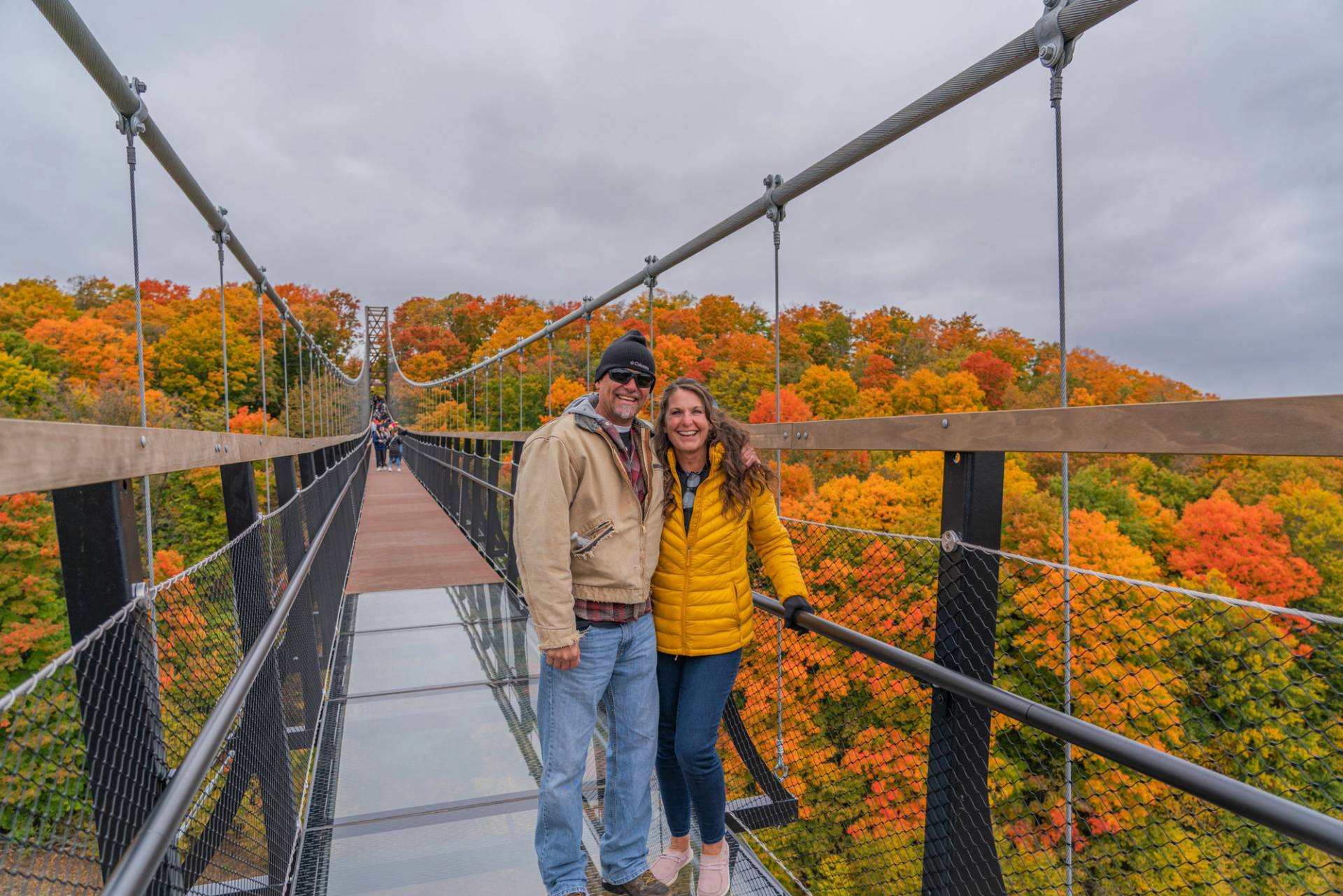 Couple smiling on the glass section of SkyBridge Michigan