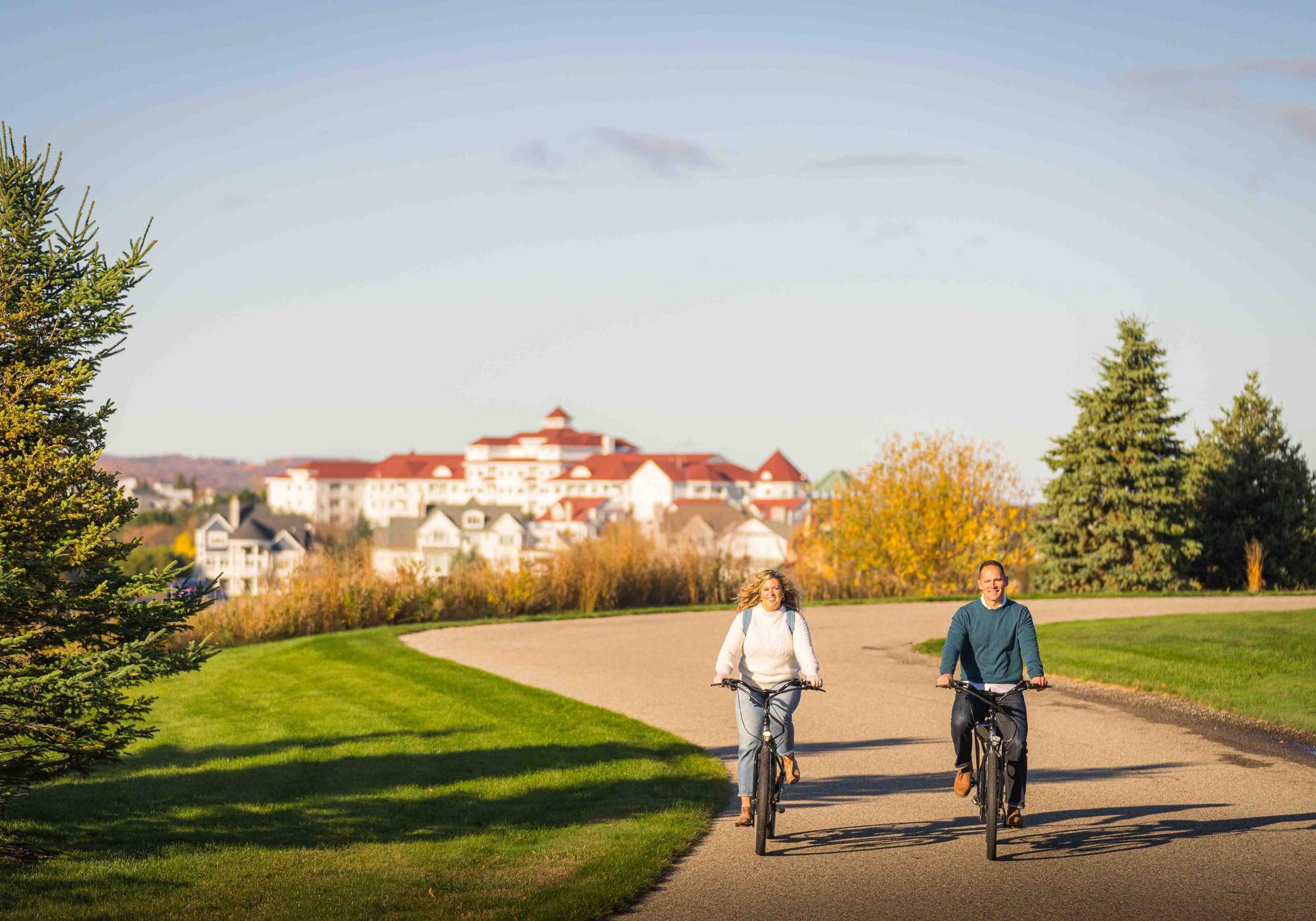 Couple biking by Inn at Bay Harbor in fall
