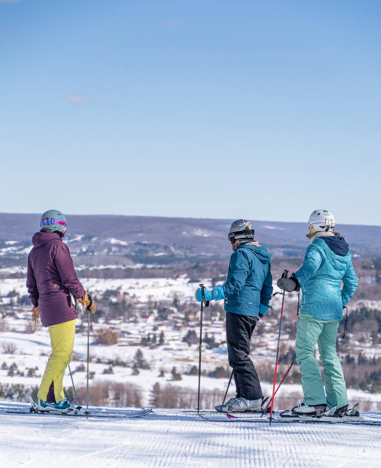 Skiers look out over winter Boyne Valley from Boyne Moutnain.