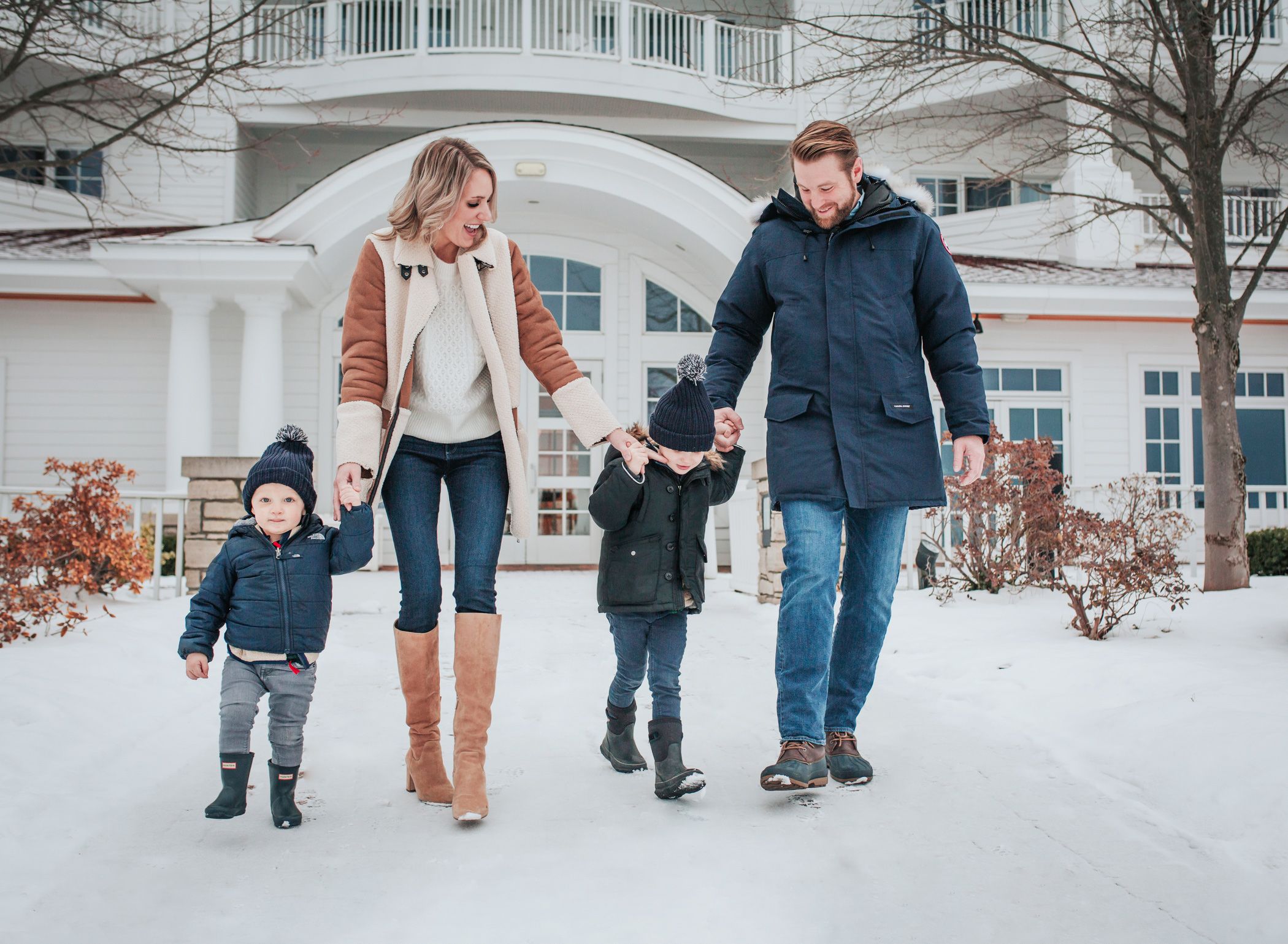 Family laughs walking in snow, Inn at Bay Harbor