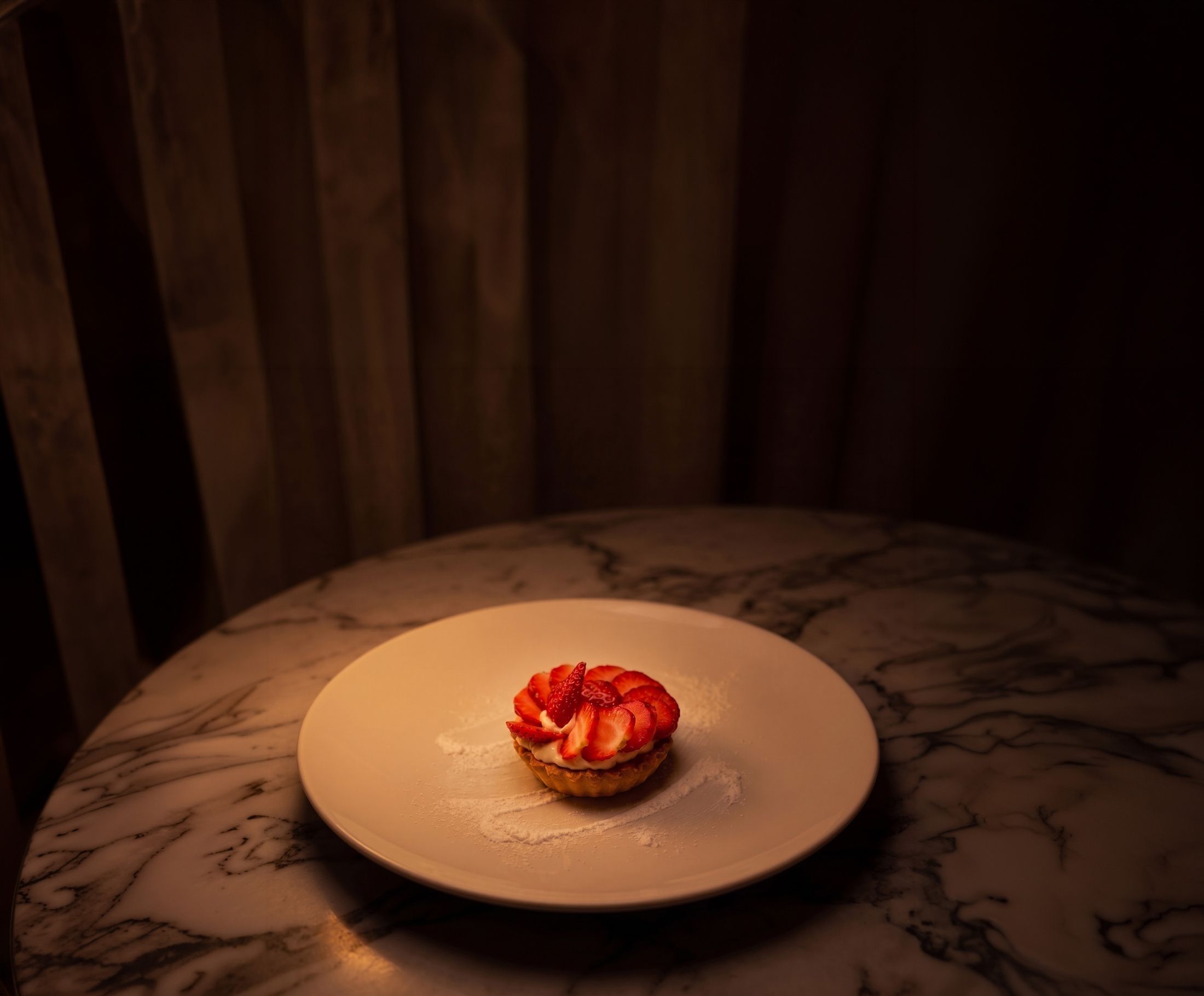 Strawberry dessert on low lit marble table