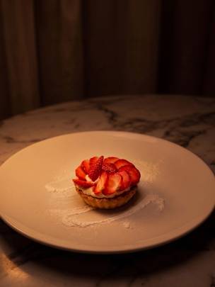 Strawberry dessert on low lit marble table