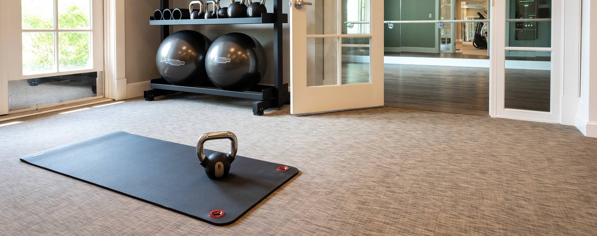 Kettle bells, yoga mat, and balance balls at Inn at Bay Harbor fitness center