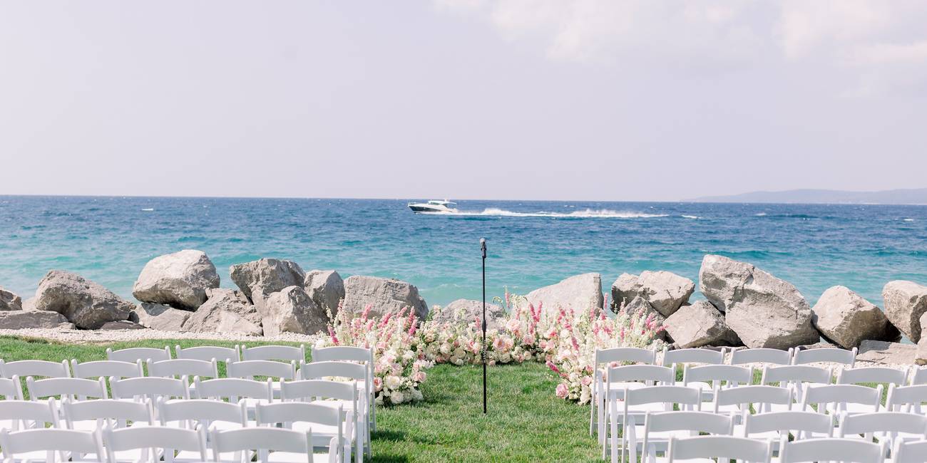 Pink floral wedding ceremony on Inn at Bay Harbor lakefront lawn