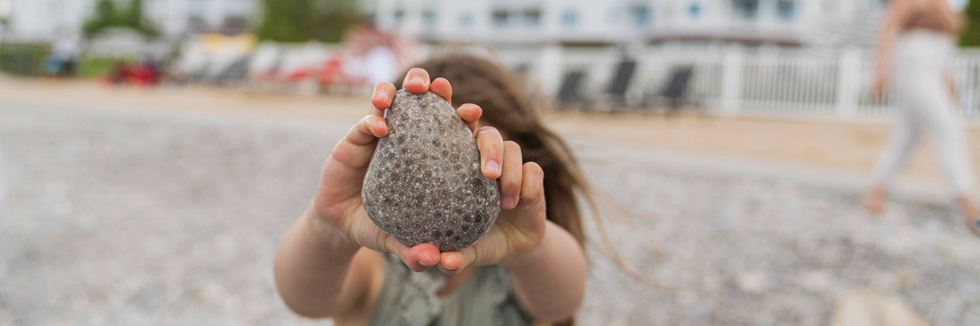 A young girl shows off a large Petoskey stone at the Inn at Bay Harbor