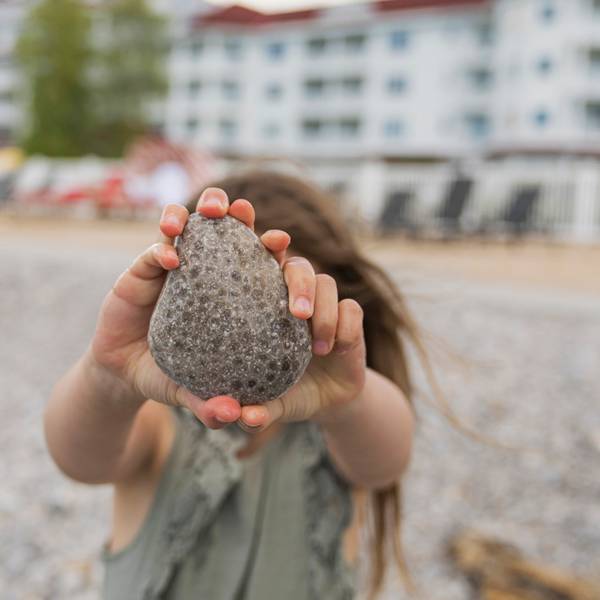 A young girl shows off a large Petoskey stone at the Inn at Bay Harbor
