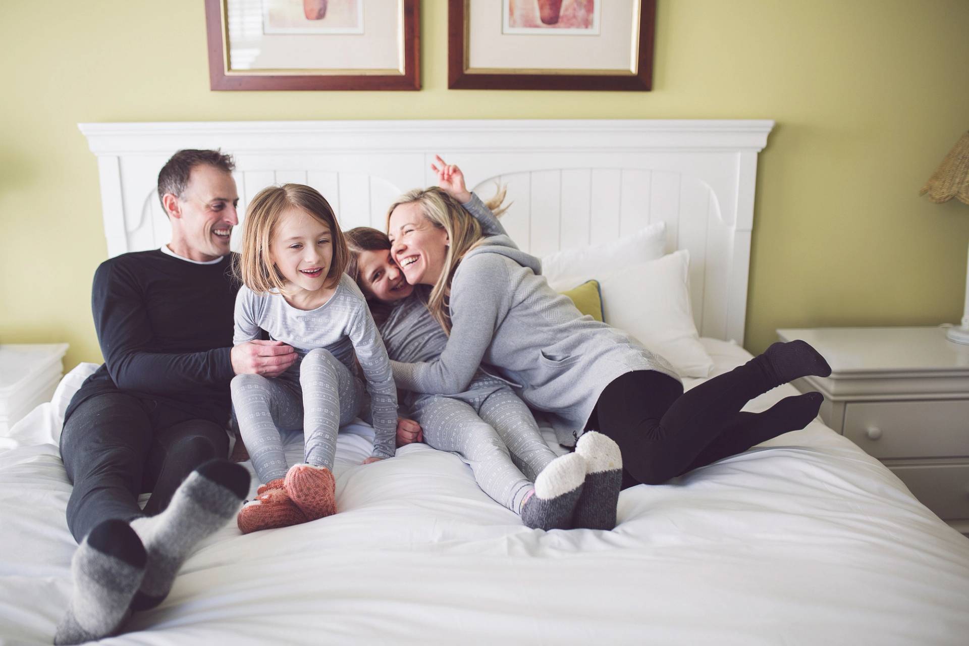 Family snuggles and laughs on bed