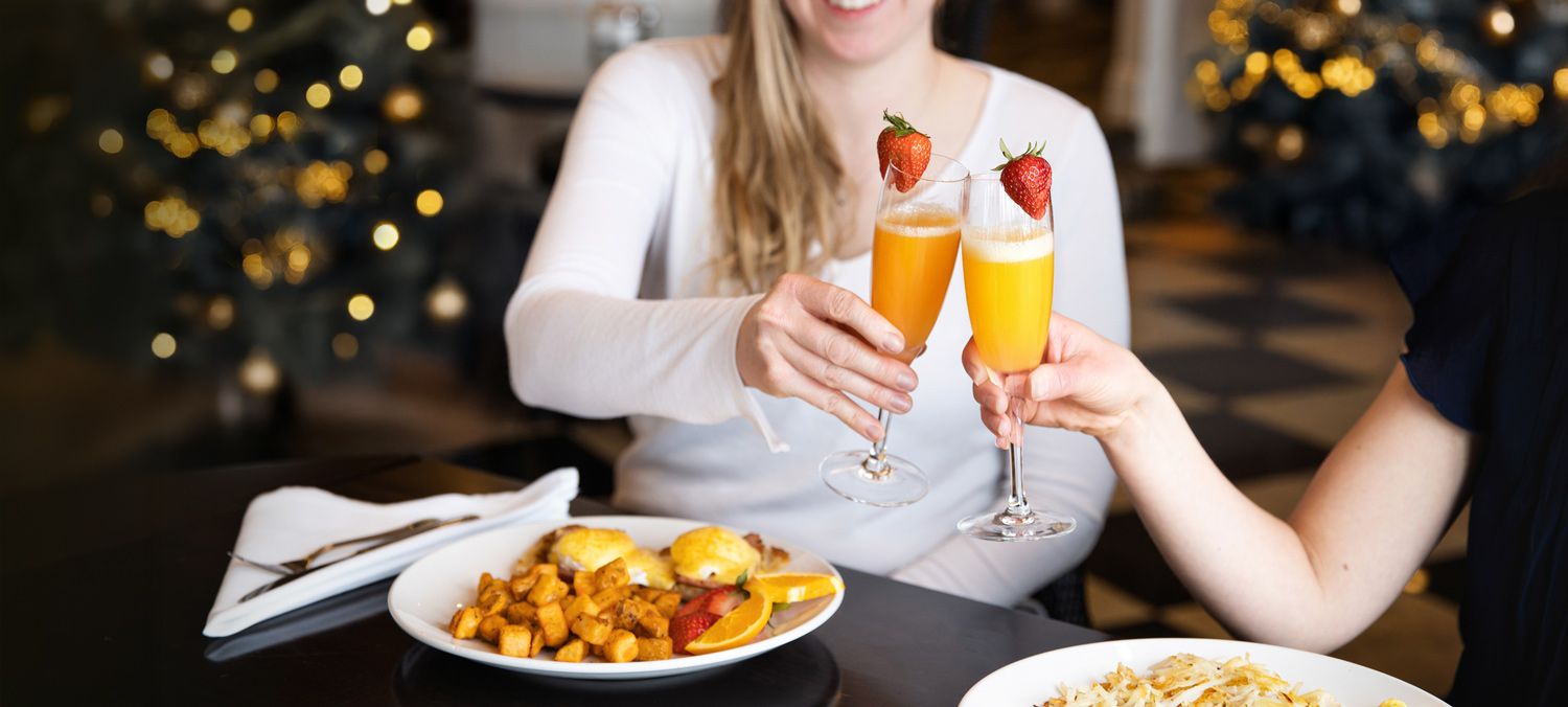 Women toast with mimosas over holiday breakfast, The Sagamore Room Inn at Bay Harbor